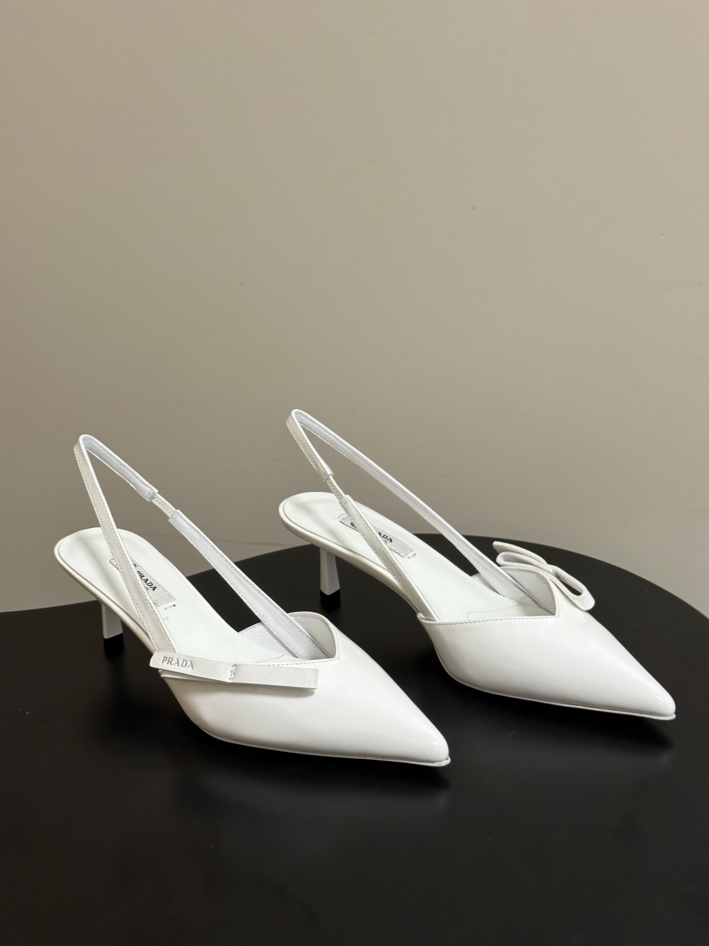 NO:818540,- 26Ss spring and summer new Prada Prada's latest catwalk style pointed toe bow high heels, retro old money style slingback kitten heel sandals, a long-lost minimalist beauty in the fashion world, fashionable and sophisticated, with a sense of luxury for daily wear. Strong lines and bold details transform the high heels that symbolize femininity into a unique and non-traditional design. The pointed toe silhouette is made of cow leather, with obvious stitching and deliberately unfinished original cutting edges. The exquisite stiletto heels perfectly present the multi-faceted style of this shoe.  Made of high-quality leather material, the texture is high-end, showing a retro and modern texture, and the craftsmanship is fine, reflecting the high-end quality of the brand. The stiletto heel design enhances the wearer's aura while maintaining good stability, suitable for daily commuting or special occasions. The upper is cow patent leather, the lining is sheepskin, and the sole is Italian genuine leather. The heel height is 7.5cm/5.5cm, and the size is 35-39 (34.40.41.42).  Customized (no return or exchange), high heels and sandals, prada, prada, sandals, high heels, cowhide, sheepskin, Leather soles19860909- 26Ss春夏新款Prada 普拉达最新走秀款尖头蝴蝶结高跟鞋 复古老钱风露跟小猫跟凉鞋 时尚界久违的极简之美 时髦又精致 日常穿出高级感 强烈的线条和大胆的细节将象征女性魅力的高跟鞋转变为独特而非传统的设计.尖头廓形采用牛皮革,具有明显的缝线和故意未完成的原始切割边缘.精致的细高跟完美呈现出此款鞋履的多面风格. 选用优质皮革材质,质感高级,呈现出复古又摩登的质感,工艺精细,体现品牌高端品质.细高跟设计,提升穿着者气场,同时保持了较好的稳定性,适合日常通勤或特殊场合穿着. 鞋面牛漆皮 内里垫脚羊皮 鞋底意大利真皮大底 跟高7.5cm/5.5cm 码数35-39（34.40.41.42 定做不退换）,高跟鞋凉鞋,prada,prada,sandals,high heels,cowhide,sheepskin,Leather soles,Women's Shoes