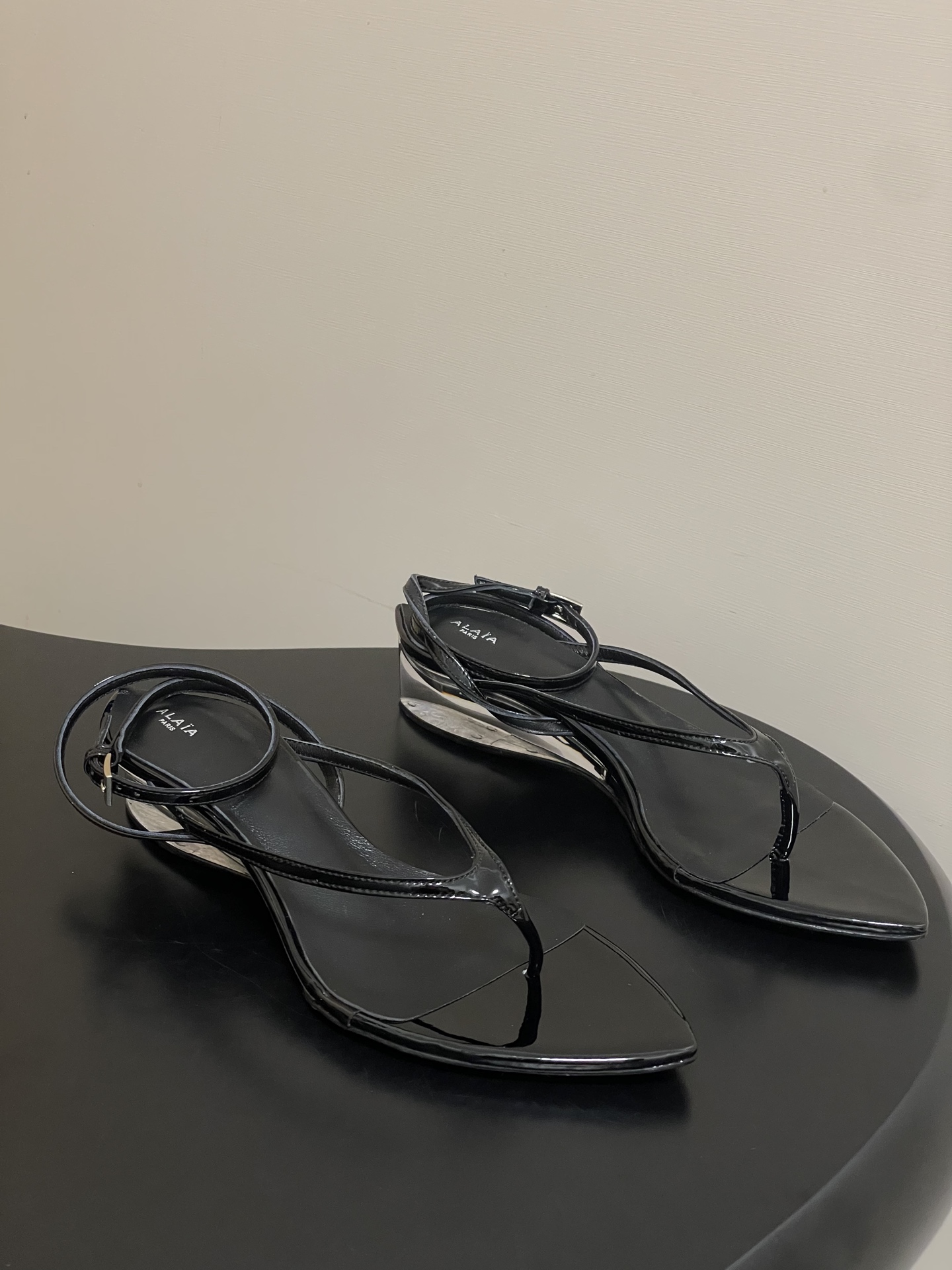 NO:876592,26ss spring and summer new style ALAIA ALAIA's latest transparent crystal heel flip-flops pointed-toe flip-flops with buckle buckle wedge sandals Colorful satin flip-flops | The flowing color poetry of summer Rub the summer palette into the satin Every touch of color brings a sense of breathability The transparent bottom holds a light ribbon The pointed toe outline is neat and gentle The freshness of fruit green, the coolness of silver gray The enthusiasm of rose red The clarity of lake blue  It looks like flowing color fragments against the transparent bottom. It brings a holiday atmosphere when you step on it. Pair it with a linen skirt or denim hot pants. It is an effortless summer relaxation. It is suitable for those who prefer 'color and texture'. It is low-key but has its own recognition. This wedge flip-flop sandal is equipped with a 30 mm plexiglass heel, a tapered toe, decorated with ankle cross straps, iconic Alaia rivets, made of patent cow leather, and a leather sole.  The upper is custom-made cow patent leather with film metal leather. The sole is Italian leather outsole (original injection molding of the forefoot). The heel height is 3cm. The size is 35-42 (40.41.42 is customized and non-returnable). Split-toe shoes, alaia, sandals, slippers, skirts, cowhide, Leather soles1986090926ss春夏新款ALAIA阿莱亚最新透明水晶跟人字凉拖鞋尖头夹脚绕带搭扣坡跟凉鞋 彩色缎面夹脚拖｜夏日里的流动色彩诗 把夏日调色盘揉进缎面里 每一抹色彩都带着通透呼吸感 透明底托着轻盈缎带 尖头轮廓利落又温柔 果绿的鲜活、银灰的清冷 玫红的热烈 湖蓝的澄澈 在透明底衬映下像流动的色彩碎片 踩上去便自带度假氛围感 配亚麻长裙或牛仔热裤 是不费力的夏日松弛感 适合偏爱“色彩与质感并存”的穿搭玩家 低调却自带辨识度 该款 坡跟人字拖凉鞋,搭配30毫米有机玻璃鞋跟,采用锥形鞋头,饰以踝部交叉系带,标志性Alaia铆钉,由漆皮牛皮革制成,采用皮革鞋底. 鞋面定制牛漆皮贴膜金属皮 鞋底意大利真皮大底（原版一致前掌注塑） 跟高3cm 码数35-42（40.41.42定做不退换）,分趾鞋,alaia,sandals,slippers,skirts,cowhide,Leather soles,Women's Shoes