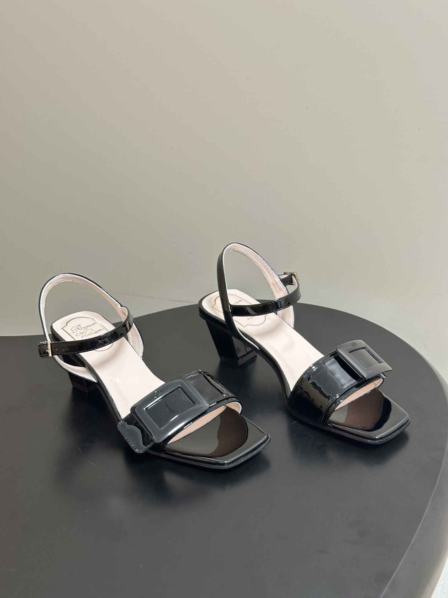 NO:874265,- 2026 spring and summer new style Roger Vivier RV classic square buckle one-strap high-heeled sandals square-toe thick-heeled sandals. With the brand's iconic square buckle element as its soul, it cleverly blends elegant silhouettes with modern design, giving it a French noble atmosphere. The upper is made of fine leather, with a one-strap design and iconic metal square buckle. Each model has its own exquisite luster, easily adapting to different styles of wearing scenes.  In terms of matching, it is an aura tool in the wardrobe. Paired with a drapey satin dress or a neat suit, it can easily create an elegant and noble dinner atmosphere. Paired with simple straight jeans or a knitted dress, it can balance the formality of high heels and create a casual and sophisticated look for daily commuting. Whether it is a date, a light social occasion or daily commuting, it can be adapted to various scenes, with an effortless sense of luxury. The upper is cow patent leather, the lining is sheepskin, and the sole is Italian genuine leather.  Heel height 4.5cm, size 35-39 (customized on 34.40.41, non-refundable), slippers and sandals, roger vivier, sandals, slippers, skirts, jeans, business suit, sheepskin, Leather soles19860909- 2026春夏新款 Roger vivier 罗杰维维亚 RV 经典方扣一字带高跟凉鞋方头粗跟凉鞋 以品牌标志性的方扣元素为灵魂,将优雅廓形与现代设计巧妙融合,自带法式贵气的氛围感.鞋面采用细腻的皮革打造,搭配一字带设计与标志性金属方扣,每一款都自带精致光泽,轻松适配不同风格的穿搭场景. 搭配上,它是衣橱里的气场利器,搭配垂坠感的缎面长裙或利落的西装套装,能轻松穿出优雅贵气的晚宴氛围,搭配简约的直筒牛仔裤或针织连衣裙,又能平衡高跟的正式感,打造日常通勤的轻熟造型,无论是约会出行、轻社交场合还是日常通勤,都能适配各种场景,自带不费力的高级感. 鞋面牛漆皮 内里垫脚羊皮 鞋底意大利真皮大底 跟高4.5cm 码数35-39（34.40.41定做不退换）,拖鞋凉鞋,roger vivier,sandals,slippers,skirts,jeans,business suit,sheepskin,Leather soles,Women's Shoes