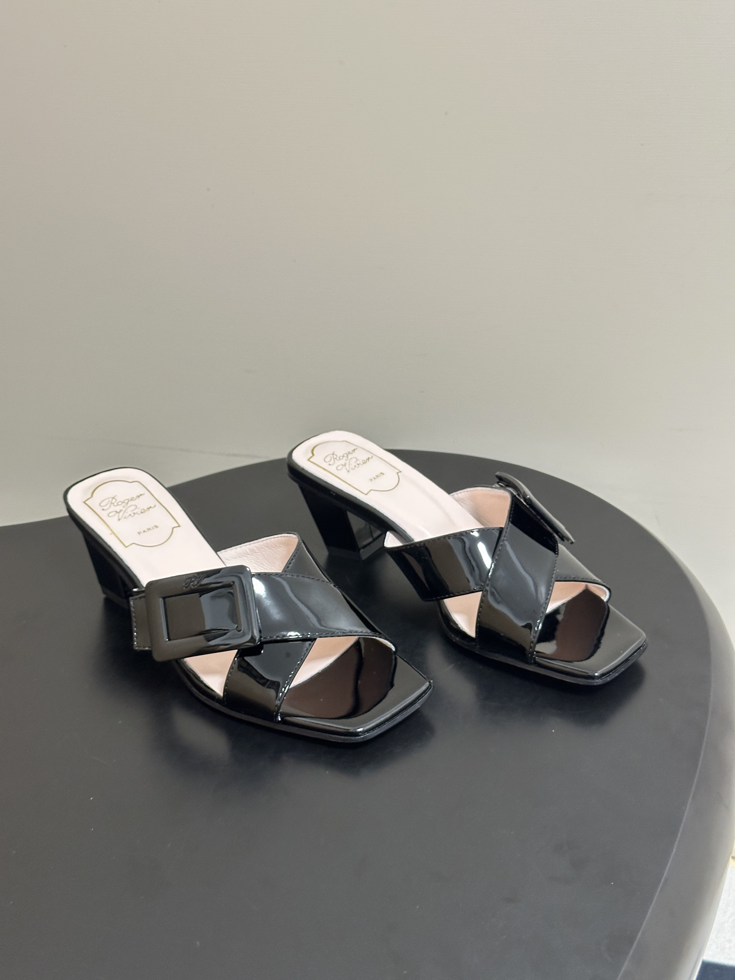 NO:874278,- 2026 spring and summer new model Roger Vivier RV classic square buckle one-strap high-heeled slippers square-toe thick-heeled slippers. With the brand's iconic square buckle element as the soul, it cleverly combines elegant silhouettes with modern design, and has a French noble atmosphere. The upper is made of fine leather, with a one-strap design and iconic metal square buckle. Each model has its own exquisite luster, easily adapting to different styles of wearing scenes.  In terms of matching, it is an aura tool in the wardrobe. Paired with a drapey satin dress or a neat suit, it can easily create an elegant and noble dinner atmosphere. Paired with simple straight jeans or a knitted dress, it can balance the formality of high heels and create a casual and sophisticated look for daily commuting. Whether it is a date, a light social occasion or daily commuting, it can be adapted to various scenes, with an effortless sense of luxury. The upper is cow patent leather, the lining is sheepskin, and the sole is Italian genuine leather.  Heel height 4.5cm, size 35-39 (customized on 34.40.41, non-refundable), slippers and sandals, roger vivier, sandals, slippers, skirts, jeans, business suit, sheepskin, Leather soles19860909- 2026春夏新款 Roger vivier 罗杰维维亚 RV 经典方扣一字带高跟拖鞋方头粗跟凉拖鞋 以品牌标志性的方扣元素为灵魂,将优雅廓形与现代设计巧妙融合,自带法式贵气的氛围感.鞋面采用细腻的皮革打造,搭配一字带设计与标志性金属方扣,每一款都自带精致光泽,轻松适配不同风格的穿搭场景. 搭配上,它是衣橱里的气场利器,搭配垂坠感的缎面长裙或利落的西装套装,能轻松穿出优雅贵气的晚宴氛围,搭配简约的直筒牛仔裤或针织连衣裙,又能平衡高跟的正式感,打造日常通勤的轻熟造型,无论是约会出行、轻社交场合还是日常通勤,都能适配各种场景,自带不费力的高级感. 鞋面牛漆皮 内里垫脚羊皮 鞋底意大利真皮大底 跟高4.5cm 码数35-39（34.40.41定做不退换）,拖鞋凉鞋,roger vivier,sandals,slippers,skirts,jeans,business suit,sheepskin,Leather soles,Women's Shoes