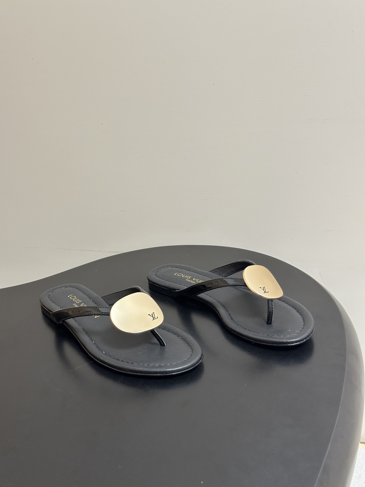 NO:875545,- 26ss new summer style LOUIS VUITTON Louis Vuitton Lv TREASURE sandals novel letter metal buckle flat flip-flops. This LV Treasure sandal is made of lacquered cow leather with slender shoelaces, combined with a curved mid-high heel that echoes the contour. The rounded metal decoration is like a pebble smoothed by the sea water, and the LV letter inscription is marked on it. The upper is cow patent leather, the lining is sheepskin, and the sole is Italian leather outsole.  Size 35-39 (40.41 customized, non-refundable), split-toe shoes, louis vuitton, louis vuitton, louis vuitton, sandals, slippers, cowhide, sheepskin, Leather soles19860909- 26ss夏季新款 LOUIS VUITTON 路易威登 Lv TREASURE凉拖鞋新颖字母金属扣平底人字拖鞋 本款LV Treasure凉鞋以漆光牛皮革裁出纤细鞋带,结合与之轮廓呼应的弧形中高跟.圆润金属装饰仿若被海水抚平棱角的鹅卵石, LV字母铭文标注其上. 鞋面牛漆皮 内里垫脚羊皮 鞋底意大利真皮大底 码数35-39（40.41定做不退换）,分趾鞋,louis vuitton,louis vuitton,louis vuitton,sandals,slippers,cowhide,sheepskin,Leather soles,Women's Shoes