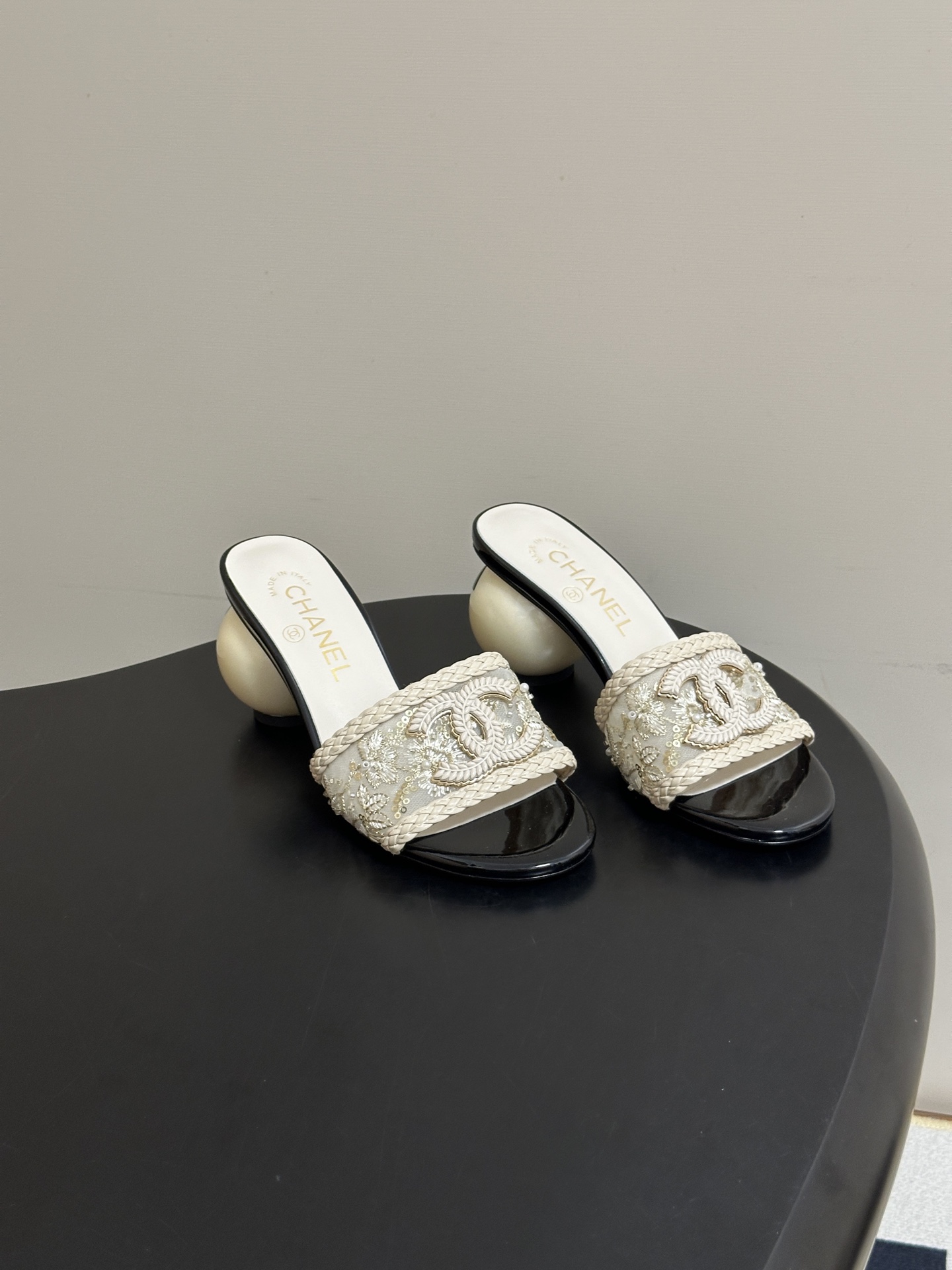 NO:921277,- Chanel Xiaoxiang 2026 spring and summer catwalk model double C giant pearl heel slippers classic double C buckle pearl rhinestone high heel/flat sandals  The high-gloss work of spring and summer integrates jewelry craftsmanship into shoes. The double C logo with diamonds is embellished with lustrous pearls, which collides with the giant pearl heel to create a dreamy tension, reflecting the bright luster with every step. The black and white color combination is classic and timeless, easily connecting afternoon tea and dinner. Effortless luxury is high-end, creating the most recognizable walking statement this summer. Customized upper material/pearl hot diamonds, inner padding sheepskin, sole Italian leather outsole  High flat heel/7cm, size 35-39 (34.40.41 custom-made, non-returnable), slippers, chanel, slippers, sheepskin, Leather soles19860909- Chanel 小香2026春夏走秀款双C巨型珍珠跟一字拖鞋经典双C扣珍珠水钻高跟/平底凉拖鞋 春夏高光之作将珠宝工艺融于鞋履.满钻双C徽标缀以莹润珍珠,与巨型珍珠鞋跟碰撞出梦幻张力,每一步都折射璀璨光泽.黑白两色配色经典隽永,轻松衔接下午茶与晚宴,以不费力的奢华就是高级,成就今夏最具辨识度的行走宣言. 鞋面定制材质/珍珠烫钻 内里垫脚羊皮 鞋底意大利真皮大底 跟高平跟/7cm 码数35-39（34.40.41定做不退换）,拖鞋,chanel,slippers,sheepskin,Leather soles,Women's Shoes