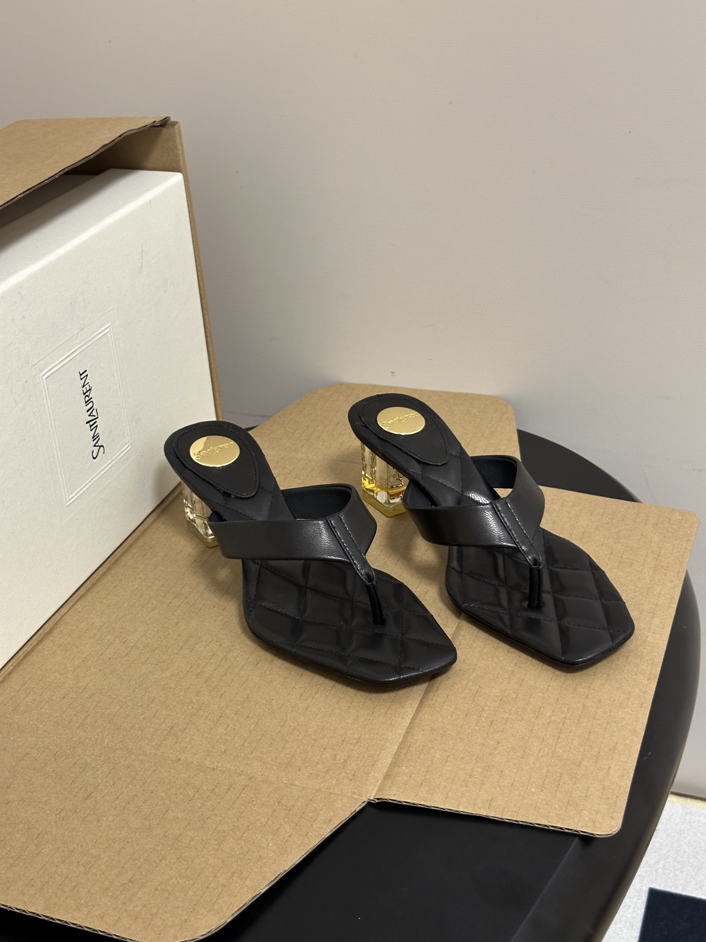 NO:928373,-Top quality (with high-end airplane case) Saint Laurent fw26 new arrival~ YSL 26s spring and summer new small square toe rhombus thick heel thong thong sandals classic letter gold label transparent crystal heel slippers. Clean square toe thong shoe shape, the upper is made of bright leather, full of classic rhombus quilting pattern, the footbed is embellished with round metal gold label, the lines are clean and simple, and the wide thong strap accommodates various foot types.  The details are exquisite and eye-catching, the even diamond pattern is three-dimensional and full, the metal round buckle is high-grade and not easy to oxidize, the square toe cut modifies the foot line without being bulky, and is a must-have sandal in summer. The upper is customized butter leather, the lining is butter leather/sheepskin, the sole is Italian genuine leather, the heel height is 5cm, the size is 35-39 (40.41.42 is customized and non-returnable), split-toe shoes, saint laurent, saint laurent, saint  laurent,slippers,sheepskin,leather soles19860909-顶级品质（配高档飞机盒） Saint Laurent 圣罗兰fw26 new arrival～ YSL 26s春夏新款小方头菱格粗跟夹趾人字凉拖鞋经典字母金标透明水晶跟拖鞋 利落方头夹趾鞋型,鞋面通体采用亮面皮质打造,满铺经典菱格衍缝纹路,鞋床点缀圆形金属金标,线条干净简约,宽幅夹趾带包容各类脚型. 细节工艺精致耐看,均匀菱格走线立体饱满,金属圆扣光泽高级不易氧化,方头剪裁修饰脚部线条不笨重,夏季刚需百搭凉拖. 鞋面定制牛油皮 内里垫脚牛油皮/羊皮 鞋底意大利真皮大底 跟高5cm 码数35-39（40.41.42定做不退换）,分趾鞋,saint laurent,saint laurent,saint laurent,slippers,sheepskin,Leather soles,Women's Shoes