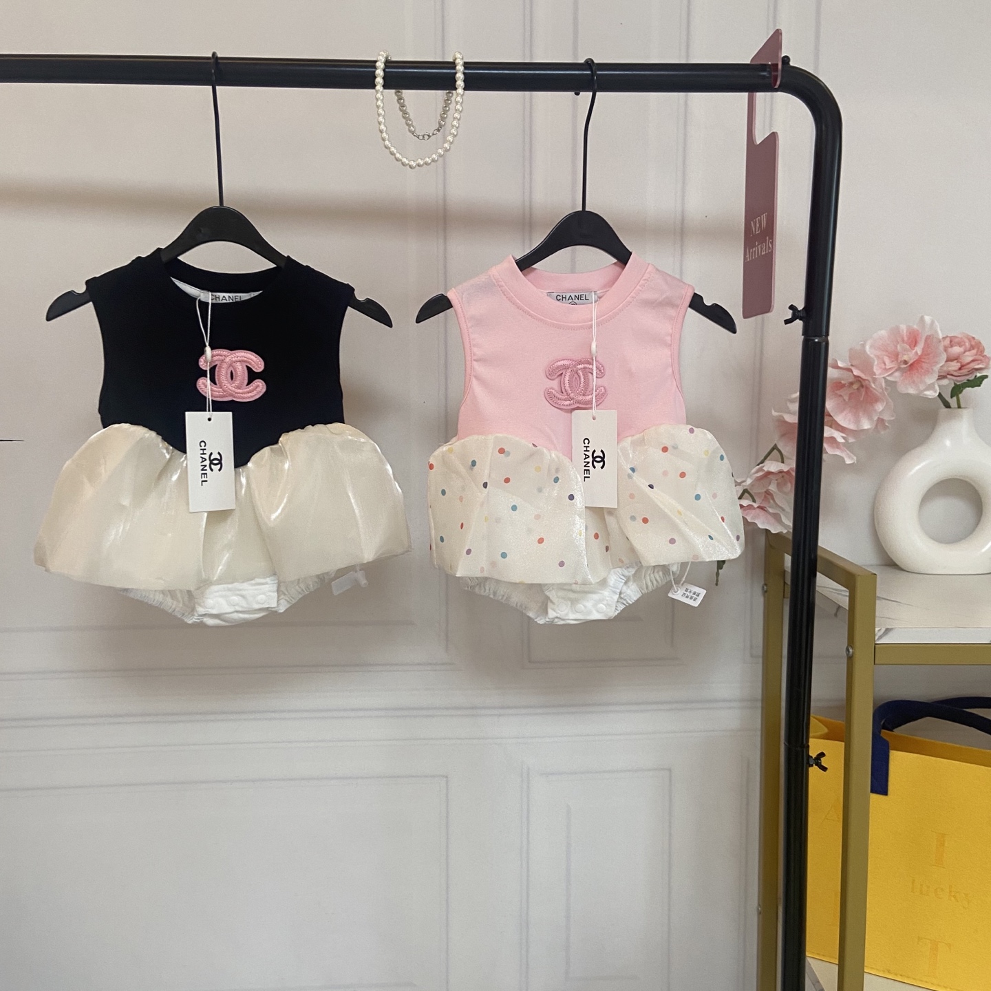 NO:850380,Kids' exclusive real shot of CH baby girl's fragrant puffy halterneck, available in two colors, and delivered with a necklace (vest style jumpsuit + mesh puffy skirt, creating a playful little princess look). The brand's iconic embroidery on the chest and the exquisite double C embroidery logo of the same color are low-key and high-end. The black and white style is sweet and cool, and the pink polka dot style is soft and cute, easily adapting to different styles of little princesses.  The fake two-piece puff skirt is designed to be a sleeveless tank top, and the lower body is spliced with a bright mesh puff skirt with fluffy curvature. It not only retains the belly protection of the halter top and is practical for convenient diaper changes, but also satisfies the ritual sense of a princess dress. The thoughtful snap button design has a full snap button closure at the crotch, making it very convenient to put on, take off, and change diapers. There is no need to take off the whole piece, and it is especially friendly to small-month-old babies.  The sleeveless vest has a refreshing and breathable design that won't make you sweaty in the summer. It can also be layered with a base layer. It's practical and can be worn all year round. Fabrics and craftsmanship | Skin-friendly and safe, taking into account appearance and comfort. The upper part of the Class A infant-grade skin-friendly fabric is made of high-count combed cotton, which is soft and breathable and will not irritate the baby's delicate skin. The lower body is made of encrypted glossy mesh, which has its own luster, feels smooth and does not tie the legs, and the wearing experience is super comfortable.  The boneless sewing process uses boneless binding to reduce the damage to the baby's skin due to friction. The baby will not be hit by threads when moving, making it safer to wear. The environmentally friendly printing and dyeing process uses reactive environmentally friendly printing and dyeing, which is not easy to fade and pilling. After multiple washings, the softness of the fabric and the stiffness of the pattern are still maintained, making it look like new after long wear.  Breathable and non-stuffy design. The combed cotton has its own breathable holes and is matched with a loose mesh skirt. It will not be stuffy when worn in summer. It can also quickly dissipate heat when the baby sweats while playing, saying goodbye to stuffy and sticky. Size 66-73-80-90cm, clothes, skirts, necklace,19860909Kids独家实拍 CH女婴香风蓬蓬哈衣 双色系可选 配送项链（背心款连体衣+网纱蓬蓬裙摆,打造俏皮小公主造型） 品牌标志性刺绣胸前精致的同色系双C刺绣标,低调又高级,黑白款甜酷、粉波点款软萌,轻松适配不同风格的小公主. 假两件蓬蓬裙摆设计上身为无袖背心哈衣,下半身拼接亮面网纱蓬蓬裙摆,自带蓬松弧度,既保留了哈衣的护肚、方便换尿布的实用性,又满足了公主裙的仪式感. 贴心按扣设计裆部全按扣开合,穿脱和更换尿布都超方便,不用整件脱下,对小月龄宝宝格外友好. 无袖背心版型无袖设计清爽透气,夏天穿不闷汗,搭配打底衫也能叠穿,实用性拉满,一年四季都能穿. 面料与工艺｜亲肤安全,兼顾颜值与舒适 A类婴幼儿级亲肤面料上身为高支精梳棉,柔软透气,不扎宝宝娇嫩肌肤；下半身采用加密亮面网纱,自带光泽感,触感顺滑不扎腿,穿着体验超舒适. 无骨缝制工艺内里全部采用无骨包边处理,减少摩擦对宝宝皮肤的伤害,宝宝活动时不会被线头硌到,穿着更安心. 环保印染工艺采用活性环保印染,不易掉色、不易起球,多次清洗依旧保持面料柔软度和版型挺括度,久穿如新. 透气不闷汗设计精梳棉自带透气孔,搭配宽松网纱裙摆,夏天穿不闷热,宝宝玩耍出汗也能快速散热,告别闷热黏腻. 码数66-73-80-90cm,衣服,skirts,necklace,,Children's