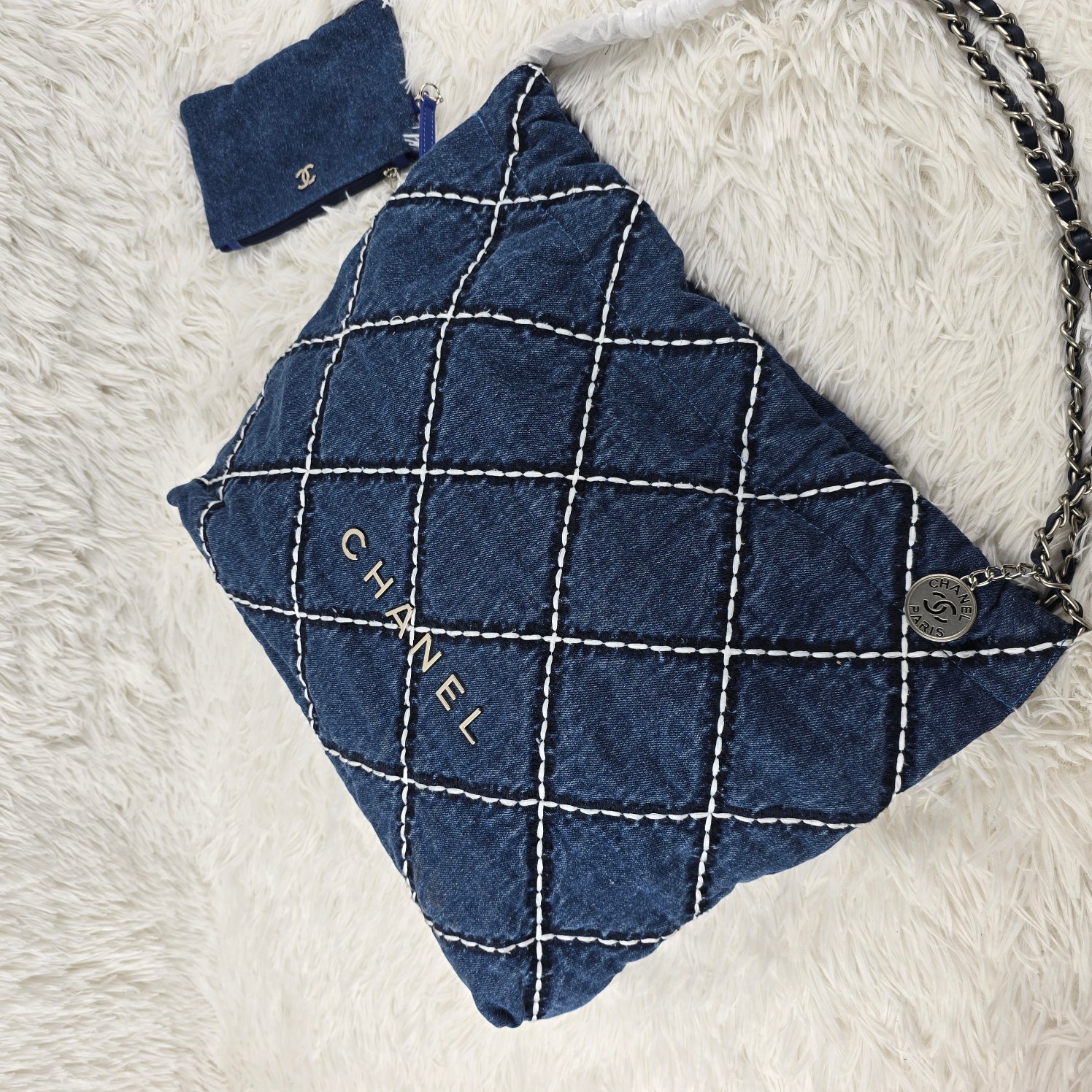 𝐂𝐡𝐚𝐧𝐞𝐥 24P 牛仔垃圾袋
24P春夏 系列又推出了新的牛仔 相比22老款的特别之处主要是包身的渐变视觉，还有大气的大菱格纹 新款的菱格纹充满了巧思!用白色和深蓝色缝线打造，刚好与蓝色包面形成了由浅到深的立体感 仍然是同色系皮穿链条，五金全部是银色，和蓝色真的好搭!时髦儿中透着一丝清冷感
尺寸：39/42/7cm
款号1002大号