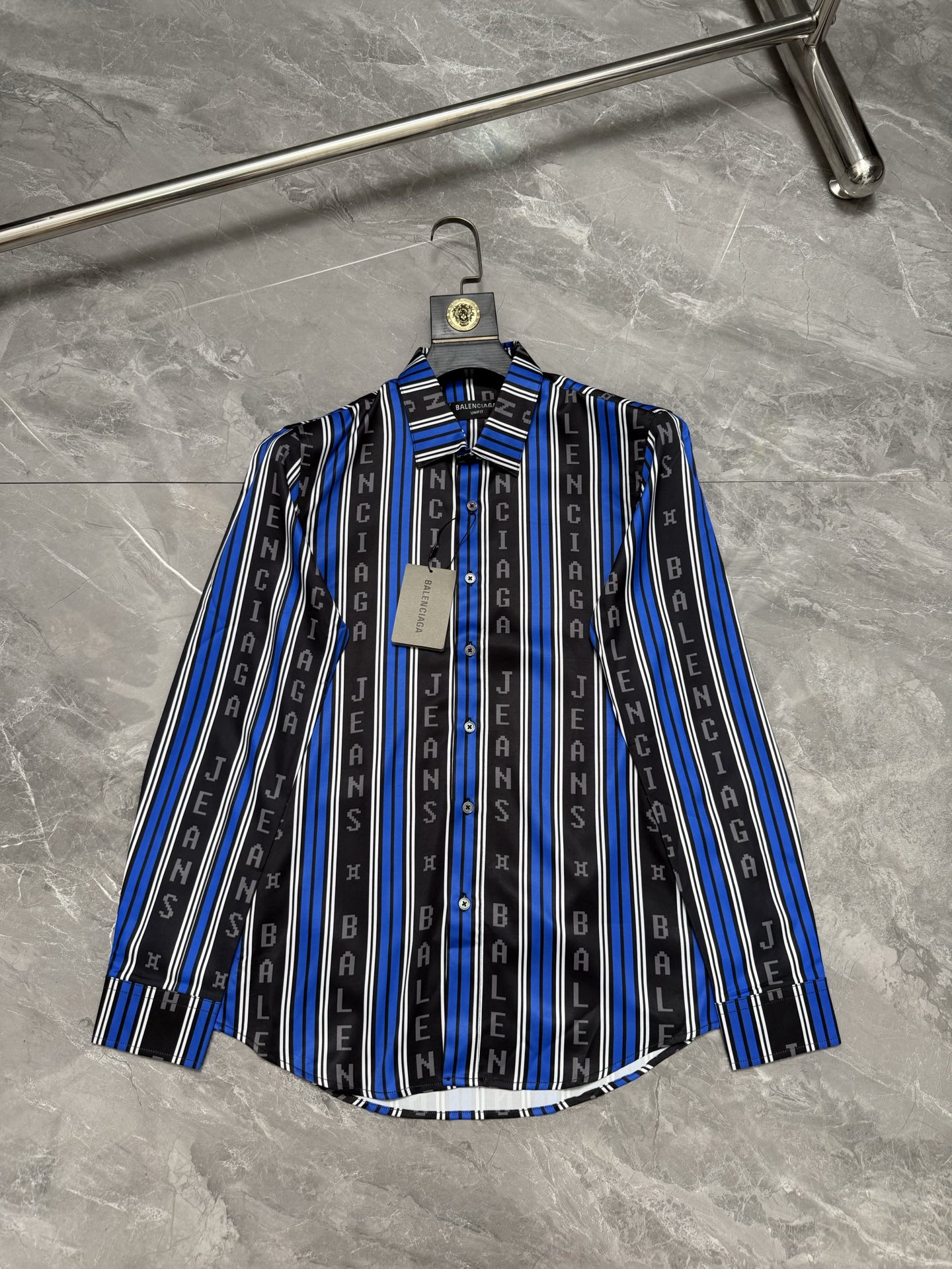 P138 Camisa con estampado de rayas verticales en azul y negro con letras BALENciag*/Paris World* Número de código: 38.3…