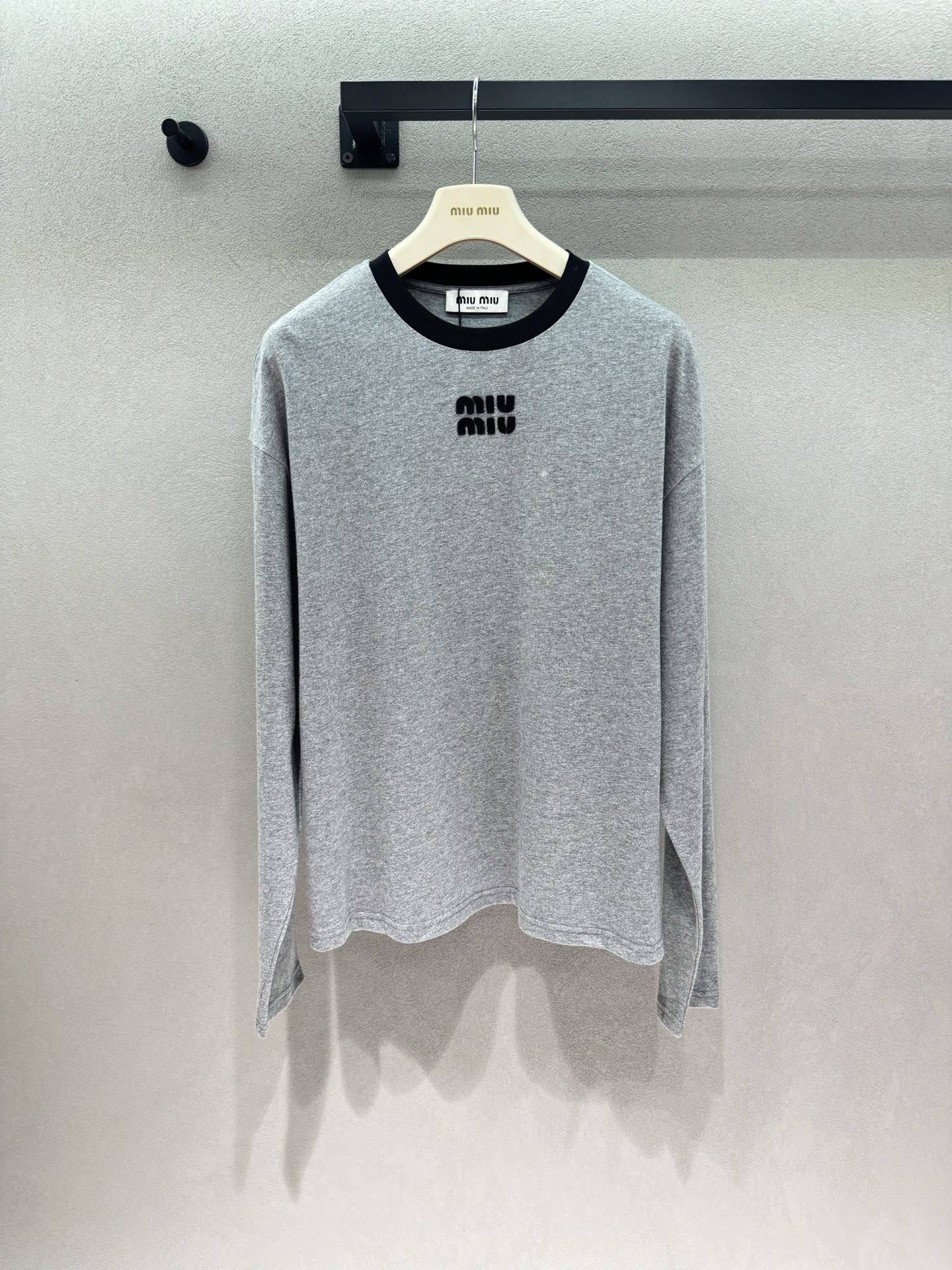 NO:956841,2026 Autumn and Winter!  MM heather gray long-sleeved top with black and gray contrasting collar, subtly adding layering. Three-dimensional flocking logo on the chest, low-key, delicate and unobtrusive. Loose and slightly short version, easily optimizes the proportion of the upper and lower body. The fabric is soft and skin-friendly, and the upper body is comfortable and breathable. It is simple and eye-catching when worn alone, and is also very suitable as an inner layer in autumn and winter. The miu style has a simple texture, easy to achieve a gentle daily style. Suitable for all skirts, jeans, and suit pants~ Three sizes!  ,,miumiu,skirts,jeans,business suit,198609092026 Autumn and Winter ！MM麻灰色长袖上衣 黑灰撞色领口,巧妙增加层次感 胸口立体植绒logo,低调精致不张扬 宽松微短版型,轻松优化上下身比例 面料软糯亲肤,上身舒适透气 单穿简约耐看,秋冬作为内搭也十分合适 miu系简约质感,轻松拿捏温柔日常风 搭配半身裙、牛仔裤、西装裤全都适配～ 三码！,,miumiu,skirts,jeans,business suit,,Women's clothing