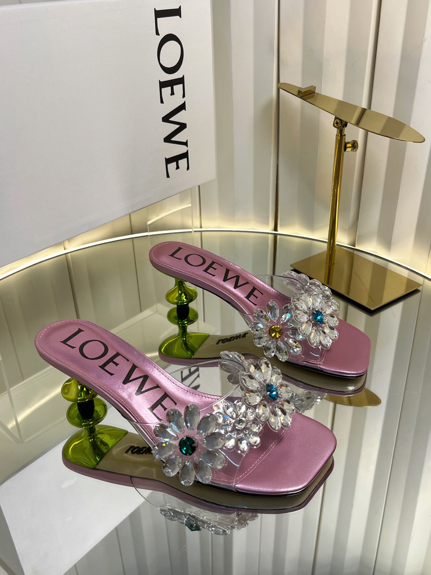 NO:902427,LOEW*26ss Summer New Rhinestone Transparent Square Toe One-Side Sandals. This pair of one-slip sandals has a neat square-toe silhouette that opens up the sense of summer sophistication. The transparent upper is studded with three-dimensional rhinestone flowers, and the blue rhinestones in the center are like fine starlight. Every step brings a smart luster, gentle and dazzling. It is suitable for different styles of wear and comes with a high-end soft light filter.  The ingenuity in the details shows the texture. The clear LOEWE logo inside the shoe is matched with exquisite metal accessories. The rhinestones are arranged tightly and firmly and are not easy to fall off. The edges of the square toe are polished and smooth without unnecessary rough edges and corners. The low-heeled design combines elegance and practicality, making it stable for daily walking. Upper film / Austrian diamond, crystal sheepskin lining, genuine leather outsole  Size 35-43 (customized sizes 40, 41, 42, 43 are non-refundable) Heel height 5cm, high heels and slippers, loewe, sandals, high heels, slippers, sheepskin, Leather soles19860909LOEW*26ss夏季新款水钻透明方头一字凉拖鞋 这双一字拖凉鞋,以利落的方头廓形开启夏日精致感,透明鞋面上缀满立体水钻花朵,中心点缀的蓝调水钻如同细碎星光,每一步都带着灵动的光泽感,温柔又耀眼.适配不同风格的穿搭,自带高级柔光滤镜. 细节处的巧思更见质感,鞋内清晰的LOEWE标识,搭配精致的金属饰件,水钻排列紧密牢固,不易脱落,方头的边缘打磨光滑,没有多余的毛边和棱角,低跟的设计兼顾了优雅与实用性,日常走路也能稳稳当当. 鞋面胶片/奥钻 内里水晶羊皮 大底真皮大底 size35-43码（40、41、42、43码定制不退换） 跟高5cm,高跟鞋拖鞋,loewe,sandals,high heels,slippers,sheepskin,Leather soles,Women's Shoes