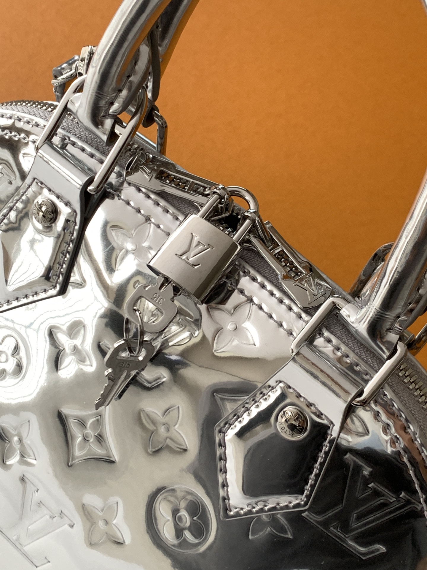 💰580顶级原单，变码芯片
M26335银色 M27037玫瑰金
本款 Alma BB 手袋以本季科技细节彰显 LV Ski 系列风范。Monogram Miroir 耐候帆布表面浸染 Silver 色调，搭配同色金属件，释放璀璨光芒。可为任意着装注入复古未来主义格调。LV 标识挂锁与可拆卸肩带完善整体。

17.5 x 11.5 x 23.5 厘米 
(高 x 宽 x 长度)
涂层帆布
涂层帆布饰边
织物内衬（棉和聚酯纤维）
金属件
双拉链开合配有挂锁
内贴袋
可收纳 6.7 寸智能手机、耳机、太阳眼镜、钥匙和口红
肩带：可拆卸，不可调节
包带半长：52.0 厘米
手柄：双手柄