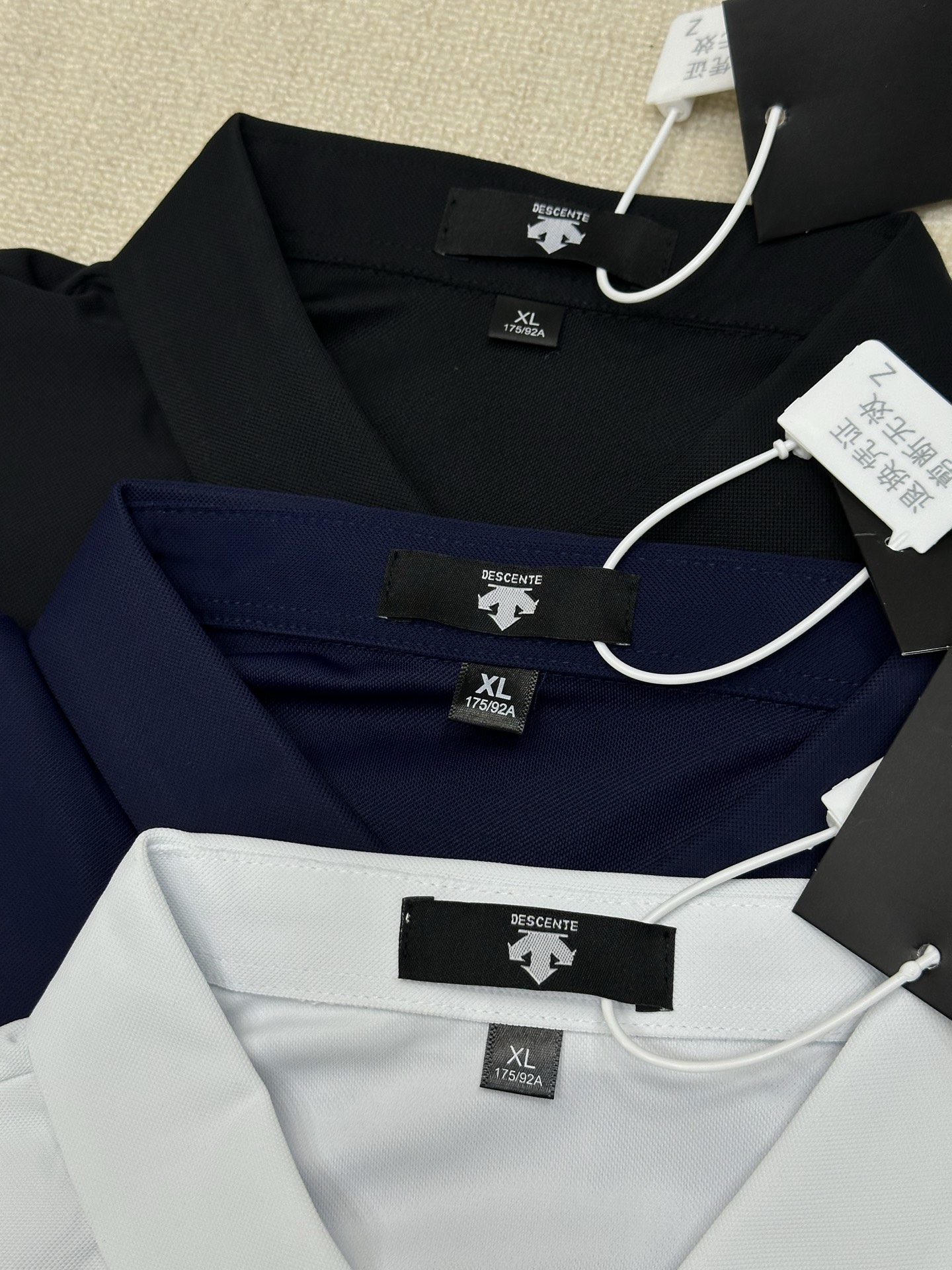 🛒购物价： 💰135
🏴‍☠️ DESCENTE 迪桑特 25ss夏季新品男女款高尔夫系列 冰丝凉感纯色polo半袖T恤


颜色：黑色 白色 藏蓝色
尺码：M-5XL


采用高品质运动属性功能性AERODRY针织面料制作的短袖POLO衫。面料轻薄柔软，舒爽透气，同时具有吸湿快干与凉感功能性，助力高强运动后回归干爽状态。
搭配ACTIVE运动版型裁剪，自然包裹贴合身形，能有效减少空气阻力，助力无忧运动体验，轻薄柔软，舒爽透气，POLO领型满足商务通勤多场景需求！！！
客订面料 经过特殊工艺处理，面料不仅柔软顺滑，还具备出色的透气性和吸湿性，即使在炎炎夏日，也能让你倍感清凉舒适。
宽松休闲的版型独具匠心，不挑身材，穿着自在无拘。搭配简约的纯色休闲裤，在午后的咖啡馆享受惬意时光；或是配上个性的印花短裤，在夏日泳池派对中大放异彩 。
穿上它，开启精致生活，每一刻都是时尚大片。


尺码表
尺码 衣长 胸围  肩宽  建议身高     建议体重
M     68    96    44   160-170CM  135-120斤
L      70    135   46   168-175CM  120-135斤
XL    72    104   48   170-175CM  135-150斤
2XL  74    108   50   168-180CM  150-165斤
3XL  76    112   52   170-185CM  165-190斤
4XL  78    116   54   170-190CM  190-200斤
5XL  80    118   56   178-200CM  200-220斤