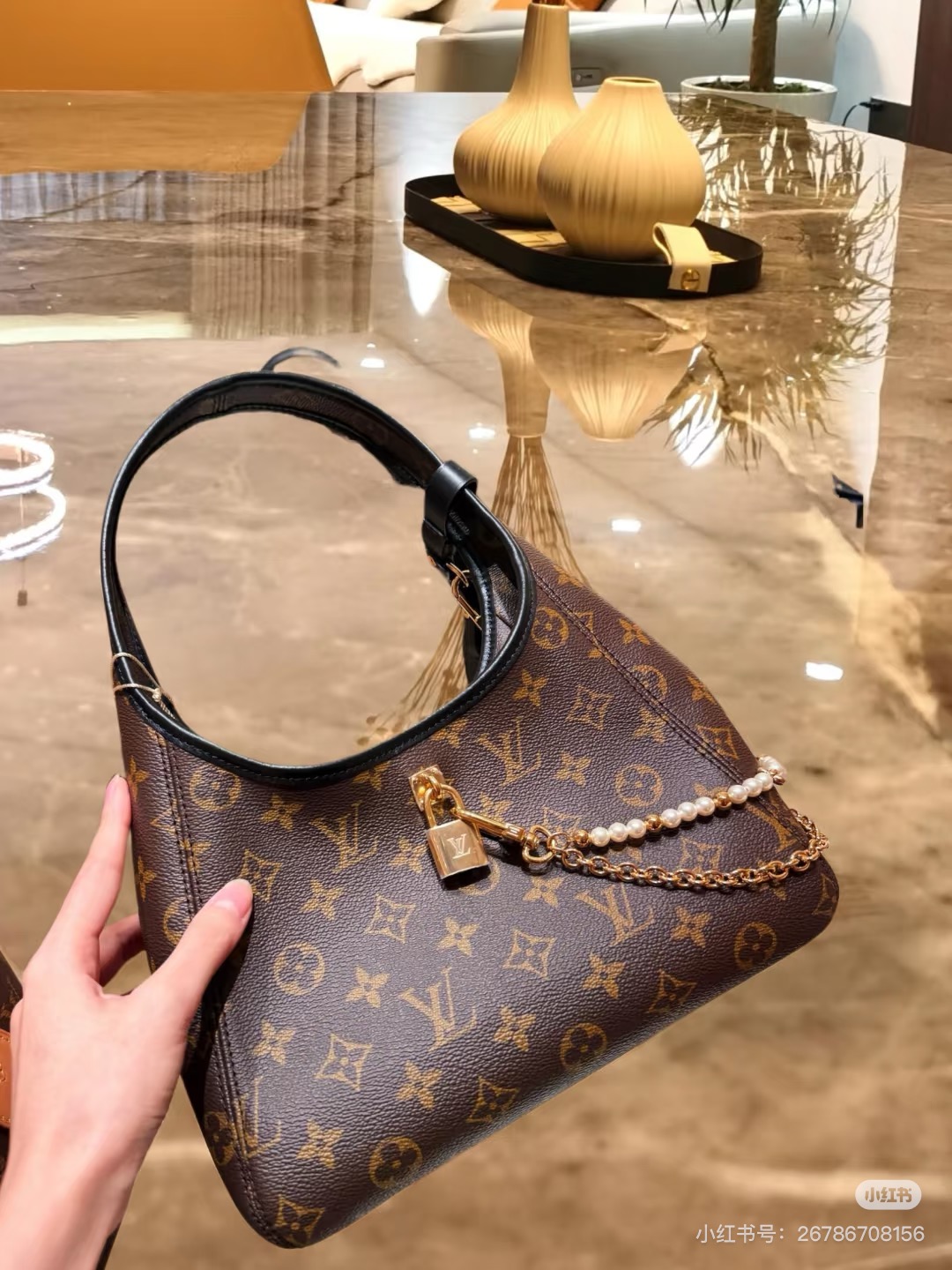 批160💰M12940老花黑色 手拎腋下包 当季新款 The Drop 小号手袋 本款 The Drop 小号手袋向 2018 年问世的 Flower Hobo 手袋汲取灵感，以经典 Monogram 帆布裁出兼具潮流格调与实用功能的雅致构型。标志性挂锁点缀名牌，与深邃皮革饰边共筑考究细节。可轻松收纳日常所需，契合都市生活节奏。15 x 12 x 28 厘米。