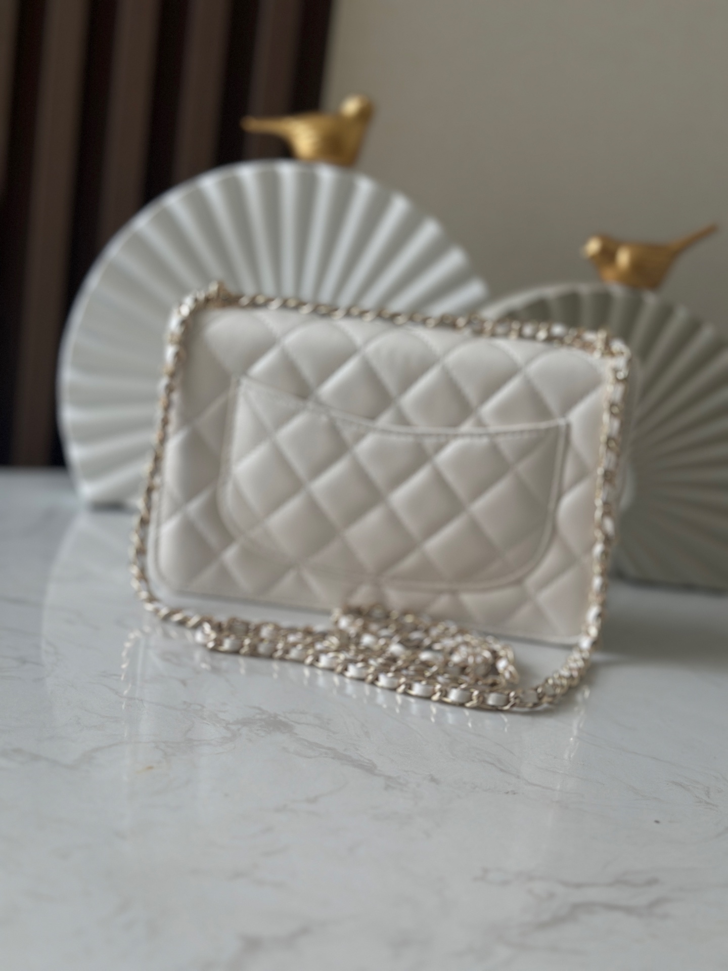 p670。chane12025春夏
chanel 太懂少女心!2025年春夏的轻巧俏
皮又精致，采用珠面小羊皮，搭配经典的菱格纹和金色 clogo。手袋上还有一个粉色心形，搭配金色链条，让人一见倾心，入坑!还可
以侧背或肩背，容量也不错，纸巾都可以放进去，通勤日常都ok
款号：66051 白色
尺寸:19.5*13*3.5
