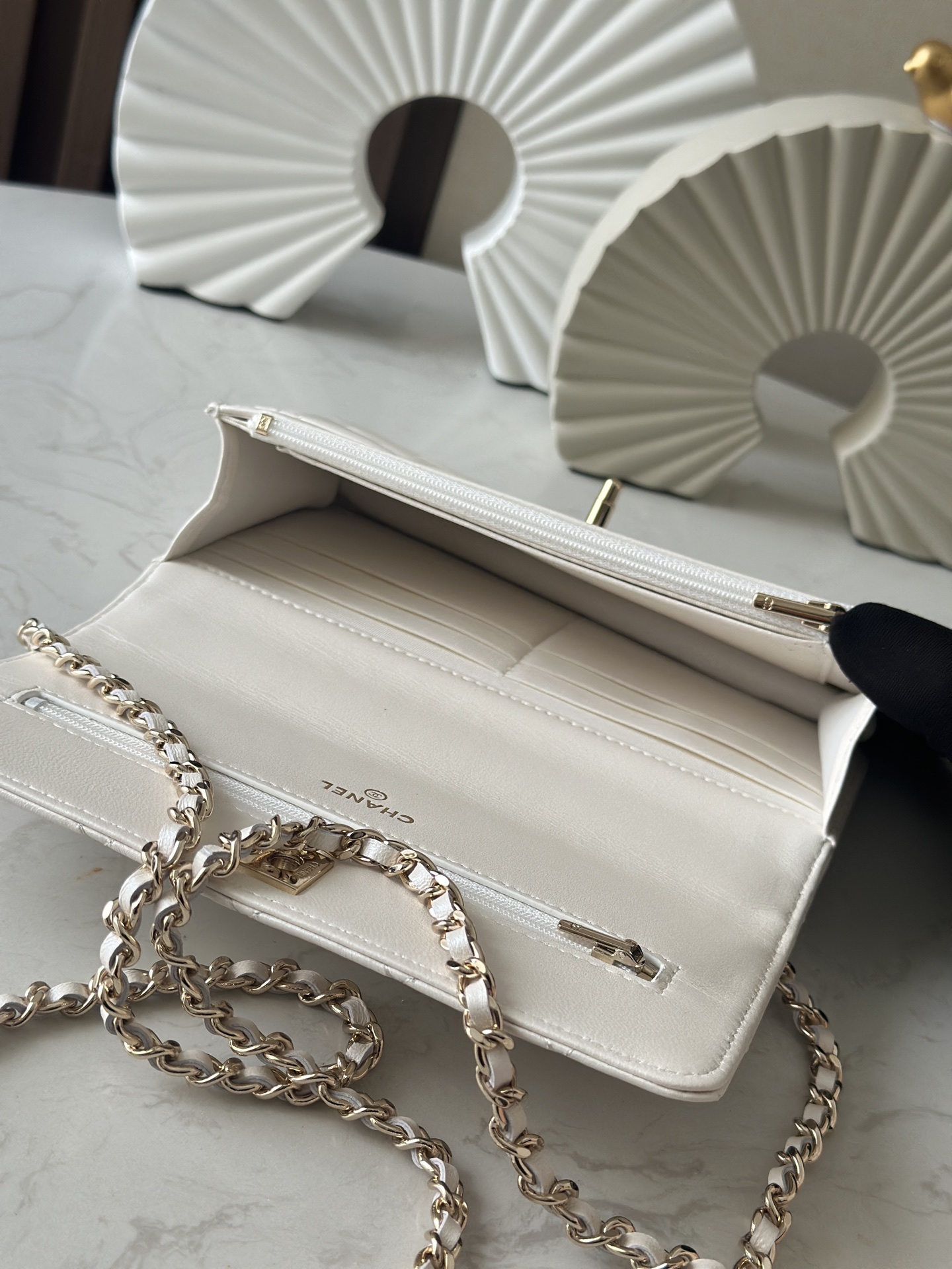 p670。chane12025春夏
chanel 太懂少女心!2025年春夏的轻巧俏
皮又精致，采用珠面小羊皮，搭配经典的菱格纹和金色 clogo。手袋上还有一个粉色心形，搭配金色链条，让人一见倾心，入坑!还可
以侧背或肩背，容量也不错，纸巾都可以放进去，通勤日常都ok
款号：66051 白色
尺寸:19.5*13*3.5
