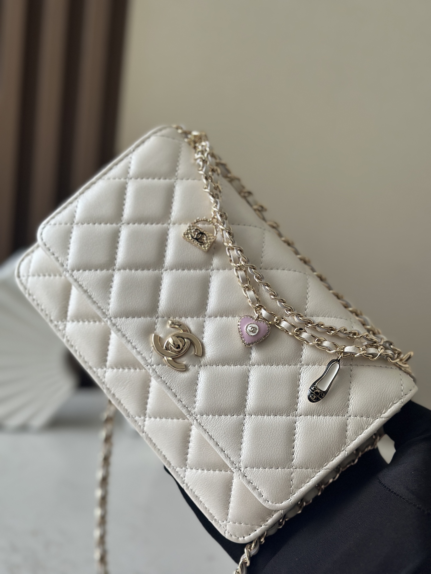 p670。chane12025春夏
chanel 太懂少女心!2025年春夏的轻巧俏
皮又精致，采用珠面小羊皮，搭配经典的菱格纹和金色 clogo。手袋上还有一个粉色心形，搭配金色链条，让人一见倾心，入坑!还可
以侧背或肩背，容量也不错，纸巾都可以放进去，通勤日常都ok
款号：66051 白色
尺寸:19.5*13*3.5
