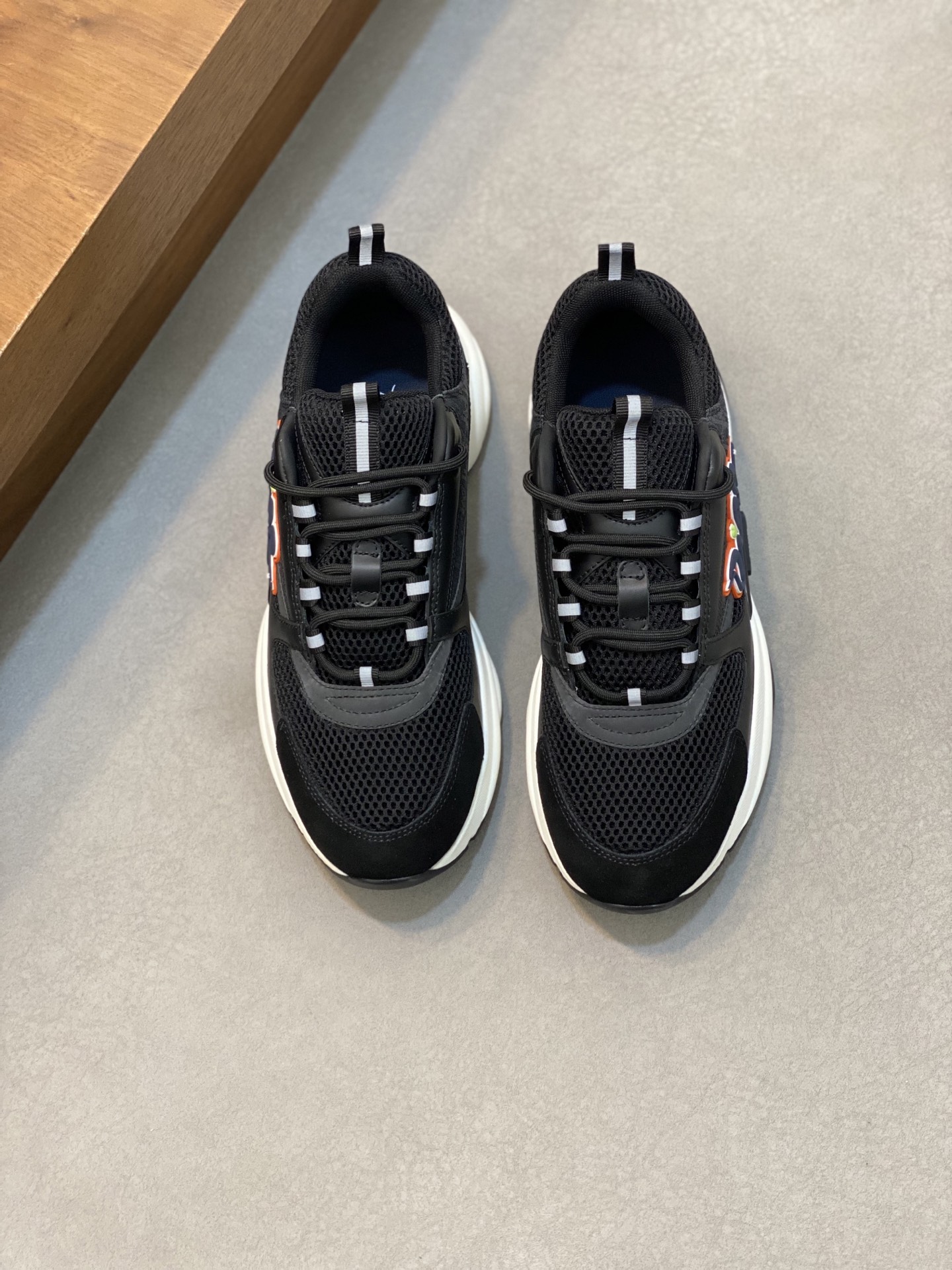 NO:271649,D x (high version) B22 men's jogging fashion sneakers, this item draws inspiration from retro jogging shoes. It adopts a thick low-top design, with a spliced ​​upper in black cowhide leather and mesh fabric, and is paired with a black and white engraved rubber sole. The black mesh fabric tongue and heel support complement the black laces, and the side is decorated with a relief 