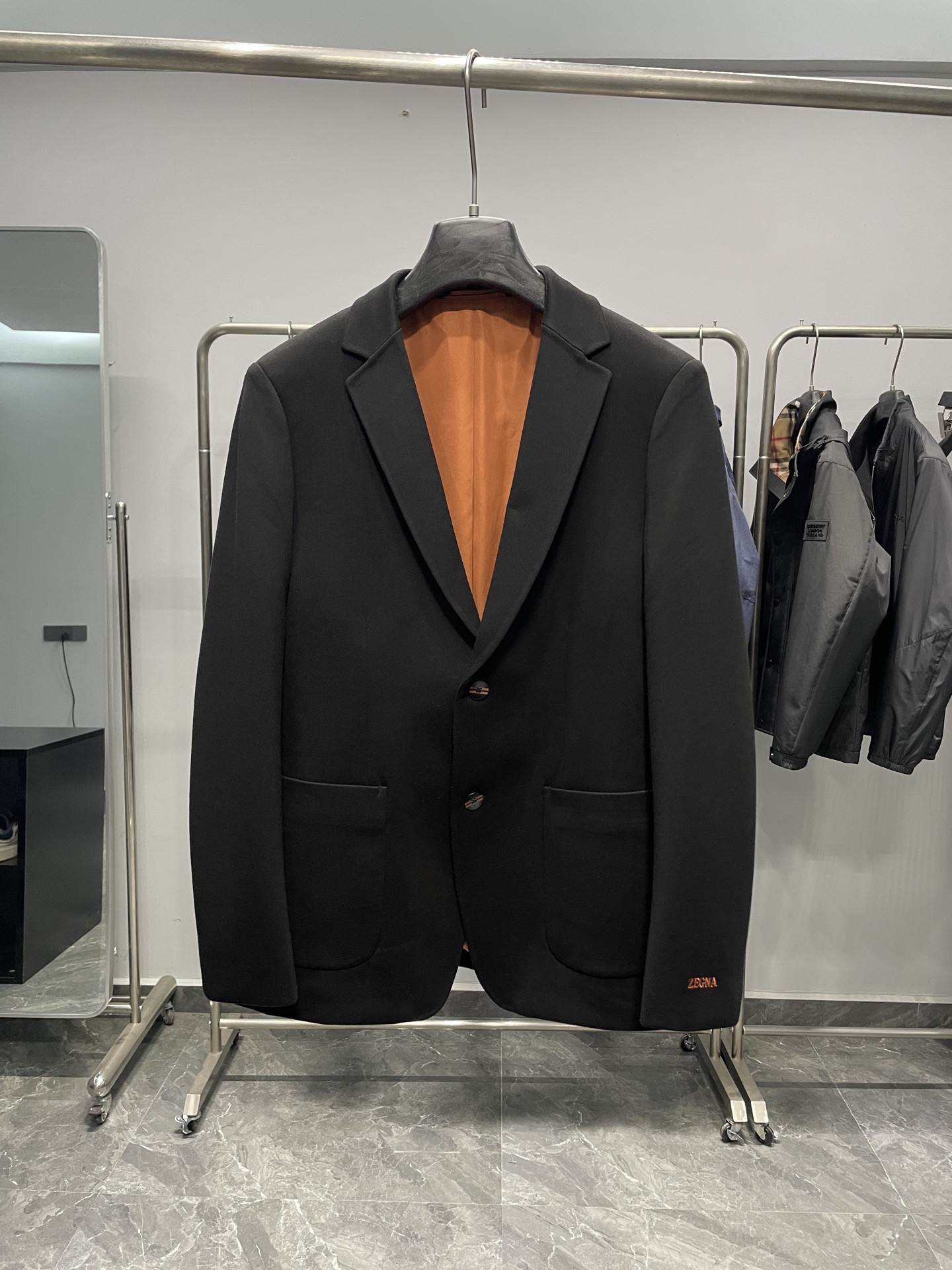 NO:518772,EZ2025FW new men's anti-wrinkle suit jacket!  The brand logo is embroidered at the cuffs of the jacket. The font is neat, and the orange embroidery thread forms a sharp contrast with the black jacket body, which not only highlights the brand identity, but also adds a sense of elegance. The button design of the jacket is round, the main body is dark, with two pink and gold stripes on it, breaking the monotony of the solid-color buttons and reflecting the sense of fashion and design in the details. At the same time, the four-eye design on the button is also classic. The color of the lining is orange, which echoes the color of the brand logo of the cuffs, and is coordinated and unified overall. The lining is smooth and flat, which can bring a comfortable wearing experience to the wearer, and to a certain extent, the crisp feeling of the jacket is added.  This suit jacket is a bellwesome style, with a classic suit collar design, smooth and natural lines, which can modify the wearer's neck line; the double button design is classic and elegant, suitable for wearing in various occasions; pockets on both sides increase practicality and decorativeness, and the overall shape is crisp, which can well shape the wearer's body. Fabric composition This suit jacket fabric composition includes 25.6 modal, 25.6 cotton, 33.7 polyester, 9.8 viscose fiber and 5.3 spandex. Modal and cotton ensure the softness and comfort of the fabric, polyester enhances the wrinkle resistance and durability of the fabric, viscose fiber enhances the drape of the fabric, and spandex increases a certain degree of elasticity, making the wearer move more freely. Color black Size M-3XL Size reference M Shoulder width 43 Bust 100 Sleeve length 62 Long 69  L size shoulder width 44 bust 104 sleeve length 63 clothes 70 XL size shoulder width 45 bust 108 sleeve length 64 clothes 71 2XL size shoulder width 46 bust 112 sleeve length 65 clothes 72 3XL size shoulder width 47 bust 116 sleeve length 66 clothes 73, Jackets & coats, business suit, alexander wang19860909EZ2025FW新款男装抗皱西服外套！品牌标识在外套袖口处,绣有醒目的“ZEG*A”品牌标志,字体工整,橙色的绣线与黑色的外套主体形成鲜明对比,既彰显了品牌身份,又增添了一丝精致感. 纽扣设计外套配备的纽扣为圆形,主体呈深色,上面带有两条粉金色的条纹装饰,打破了纯色纽扣的单调感,在细节处体现时尚感与设计感,同时纽扣上的四眼设计也较为经典 . 内衬内衬颜色为橙色,和袖口的品牌标志颜色呼应,整体协调统一.内衬光滑平整,能为穿着者带来舒适的穿着体验,并且在一定程度上增加了外套的挺括感. 这款西服外套属于便西款式,有着经典的西装领设计,线条流畅自然,能够修饰穿着者的颈部线条；双扣设计经典大方,适合多种场合穿着；两侧配有口袋,增加了实用性和装饰性,整体版型挺括,能够很好地塑造穿着者的身形. 面料成分这款西服外套面料成分包含25.6莫代尔、25.6棉、33.7涤纶、9.8粘纤和5.3氨纶.莫代尔和棉保证了面料的柔软舒适与透气性,涤纶增强了面料的抗皱性和耐用性,粘纤提升面料垂坠感,氨纶则增加了一定的弹性,使穿着者活动更加自如 . 颜色黑色 尺码M-3XL 尺寸参考 M码肩宽43胸围100袖长62衣长69 L码肩宽44胸围104袖长63衣长70 XL码肩宽45胸围108袖长64衣长71 2XL码肩宽46胸围112袖长65衣长72 3XL码肩宽47胸围116袖长66衣长73,,jackets & coats,business suit,alexander wang,Men's clothing