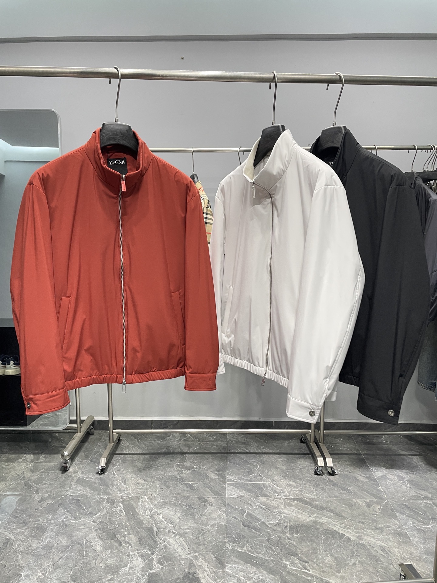 NO:606445,EZ25FW men's spring and summer new product Motorin 100cc microfiber short jacket! It is available in three classic colors of red, white and black. The overall design is simple and elegant, and the short version is neat and stylish, suitable for various occasions. Hang it on a hanger, and the crisp version can naturally show off the lines of the jacket.  The stand-up collar design can keep the wind and cold to a certain extent while maintaining a sense of fashion. There is a brand label on the inside of the collar, and the word 'Z*G' is printed on the label to highlight the brand identity. It is also marked with 'HIGHPERFO', hinting at the style of this jacket.  High-performance fabric features. The zipper has a high-quality texture, with the word 'Z*G' on the zipper head, and the zipper puller is made of the same color material as the jacket (take the red model as an example), which gives a stronger overall feel. The zipper is smooth and easy to pull, and can fit the neckline well when closed, enhancing the windproof effect.  It is designed with buttons and the 'ZE*NA' brand logo is engraved on the buttons. Not only can the tightness of the cuffs be adjusted according to needs, but it also adds a sense of detail and sophistication to the jacket. The hem has an elastic edge design, which can better fit the body and maintain warmth. It can also create a better wearing shape and avoid loose hems that affect the overall beauty. There is a brand logo strip decoration under the neckline on the back, which adds a touch of highlight and uniqueness to the overall simple design, making the back shape not monotonous.  The fiber component of this fiber is polyester fiber, which is a microfiber material. This fabric is wear-resistant and easy to care for, and is suitable for daily wear. Color Orange, White, Black Size M-3XL Size Reference  2XL, shoulder width 53, chest 124, sleeve length 62, dress length 67 3XL, shoulder width 54, chest 128, sleeve length 63, dress length 68.,,jackets & coats,jackets & coats,alexander wang19860909EZ25FW男装春夏新品Motorin 100cc微纤维短夹克!提供了红、白、黑三种经典颜色款式 ,整体设计简约大方,短款版型利落有型,适合多种场合穿着.挂在衣架上,挺括的版型能够自然地展现出夹克的线条. 立领设计,在保持时尚感的同时,还能在一定程度上抵御风寒.领口内部带有品牌标签,标签上印有“Z*G”字样,彰显品牌身份,同时还标注有“HIGHPERFO”,暗示了这款夹克的高性能面料特质.拉链质感高级,拉链头上带有“Z*G”字样,并且拉链拉片采用与外套同色的材质（以红色款为例）,整体感更强.拉链顺滑易拉,闭合时能很好地贴合领口,增强防风效果. 采用纽扣设计,纽扣上刻有“ZE*NA”品牌标志,不仅可以根据需求调节袖口的松紧度,同时也增加了夹克的细节感和精致感 .下摆处带有弹性收边设计,能够更好地贴合身体,保持温暖,同时也能塑造更好的穿着造型,避免下摆松散影响整体美观.背部领口下方带有一块品牌标志条形装饰,为整体简约的设计增添了一丝亮点和独特性,使背部造型不单调. 这款纤维成分为聚酯纤维,属于微纤维材质,这种面料具有耐磨、易打理等特点,适合日常穿着. 颜色橘红色、白色、黑色 尺码M-3XL 尺寸参考 M码肩宽50胸围112袖长59衣长64 L码肩宽51胸围116袖长60衣长65 XL码肩宽52胸围120袖长61衣长66 2XL码肩宽53胸围124袖长62衣长67 3XL码肩宽54胸围128袖长63衣长68.,,jackets & coats,jackets & coats,alexander wang,Men's clothing