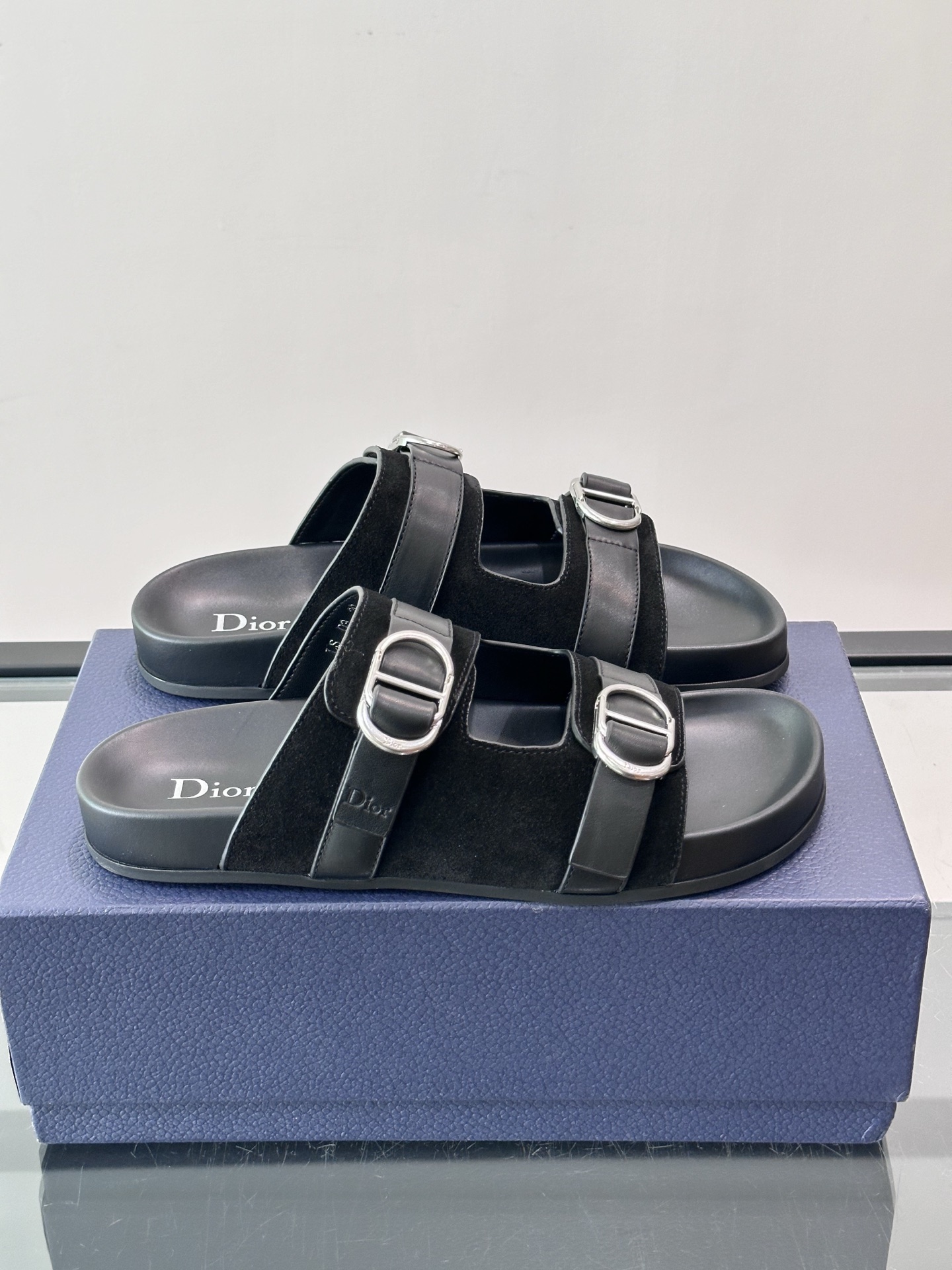 NO:955859,Size 38-46 Dior Aqua Sandals Suede Calfskin This reimagined Dior Aqua sandal reflects Jonathan Anderson's creative vision, striking a delicate balance between comfort and casual elegance. Suede calfskin straps with CD buckle provide an ideal fit, while a molded insole provides a lightweight, flexible design ideal for matching with any outfit this season. Adjustable straps with metal-coated metal buckles.  Black PU and leather insole that adapts to the shape of the foot. Black rubber sole engraved with cannage pattern. Good-looking and easy to wear,,dior,sandals,cowhide19860909码数38-46 Dior Aqua 凉鞋 绒面牛皮革 这款经重新演绎的 Dior Aqua 凉鞋展现乔纳森·安德森 (Jonathan Anderson) 的创意视角,在舒适与休闲优雅之间取得微妙的平衡.绒面牛皮革饰带搭配 CD 搭扣,打造理想的贴合度.而适应足形的内底则带来轻盈、柔韧的设计,是与本季各式装扮搭配的理想之选. 可调节饰带搭配金属覆层金属搭扣 适应足形的黑色 PU 和皮革内底 黑色橡胶鞋底镌刻有藤格纹图案 好看又好穿,,dior,sandals,cowhide,Men's shoes