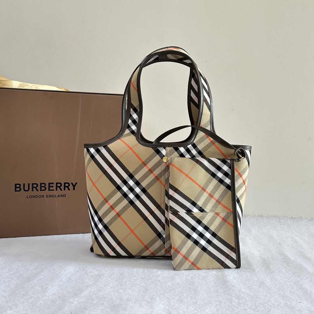 Burberry. Soft and structured tote bag, made of cotton twill fabric and crafted in Italian workshops. Embellished with worsted new season Burberr