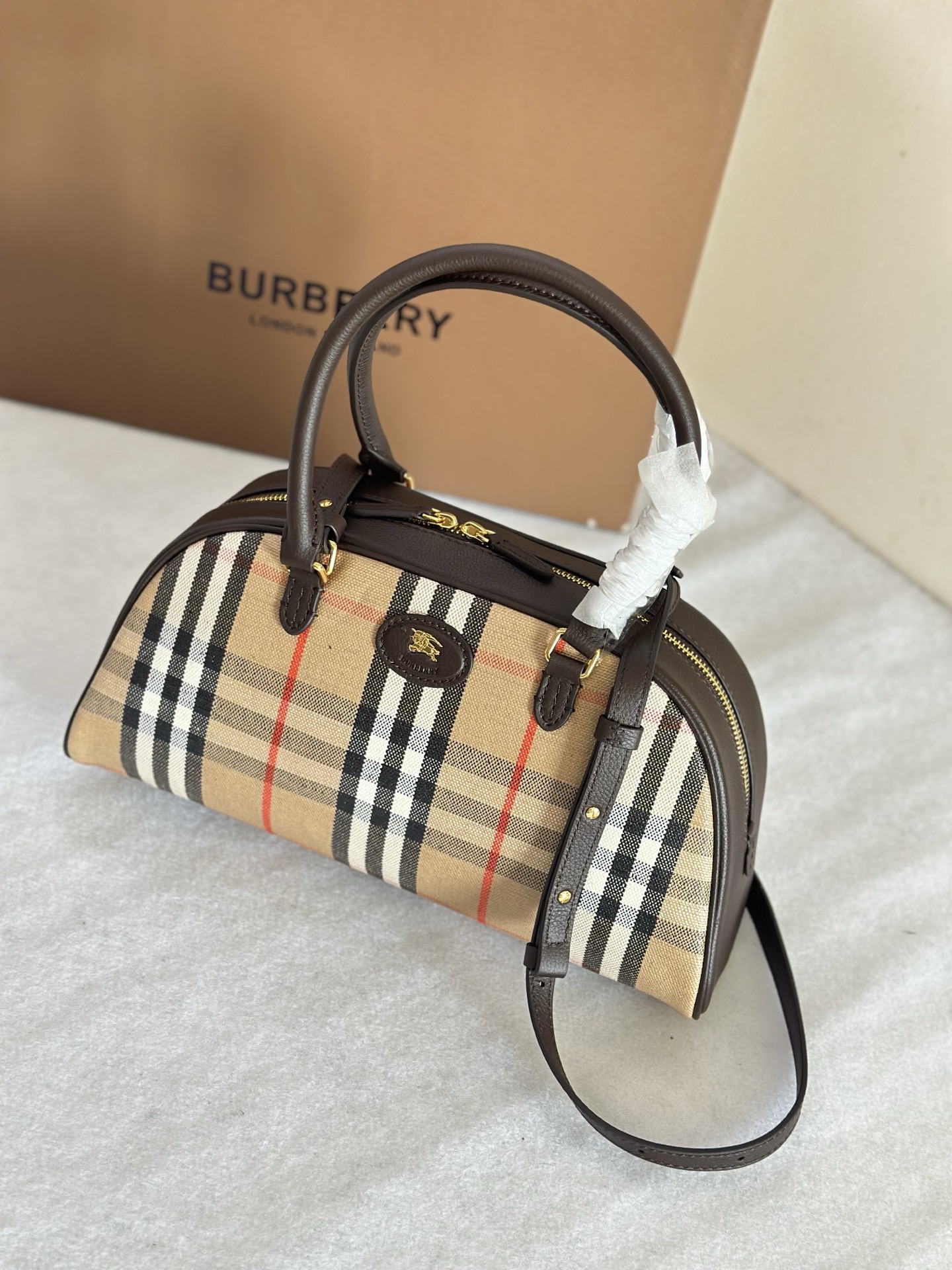 Burberry The top B-bag Highlands bowling bag is built with outdoor design concepts in mind. Crafted in an Italian workshop from cotton and linen
