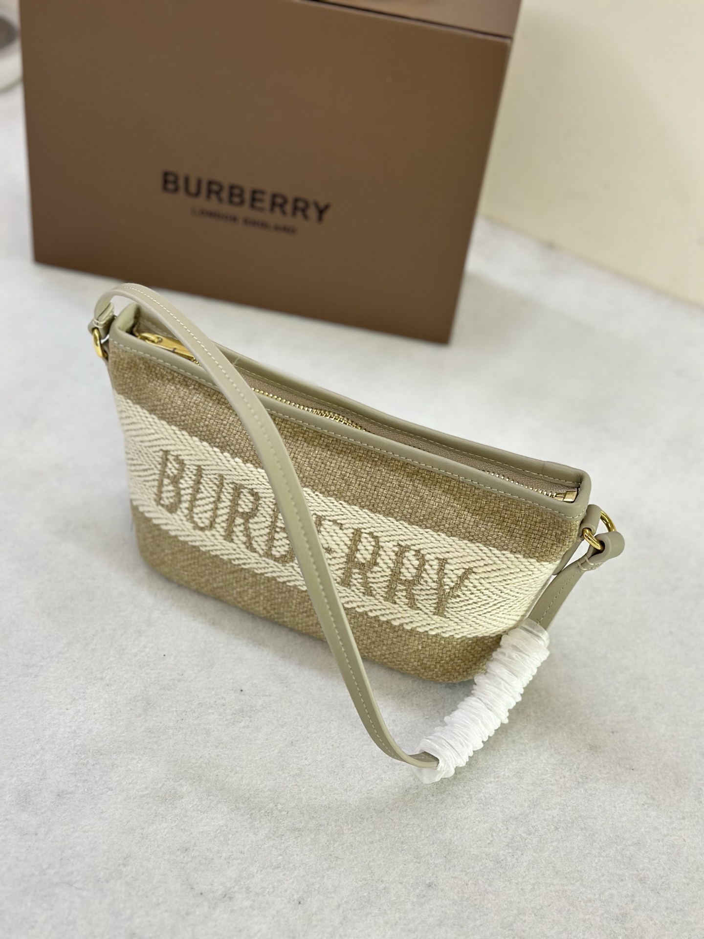 Compact shoulder bag in Burberry original logo canvas, made of linen and cotton blend fabric. Crafted in an Italian workshop, it is decorated wit