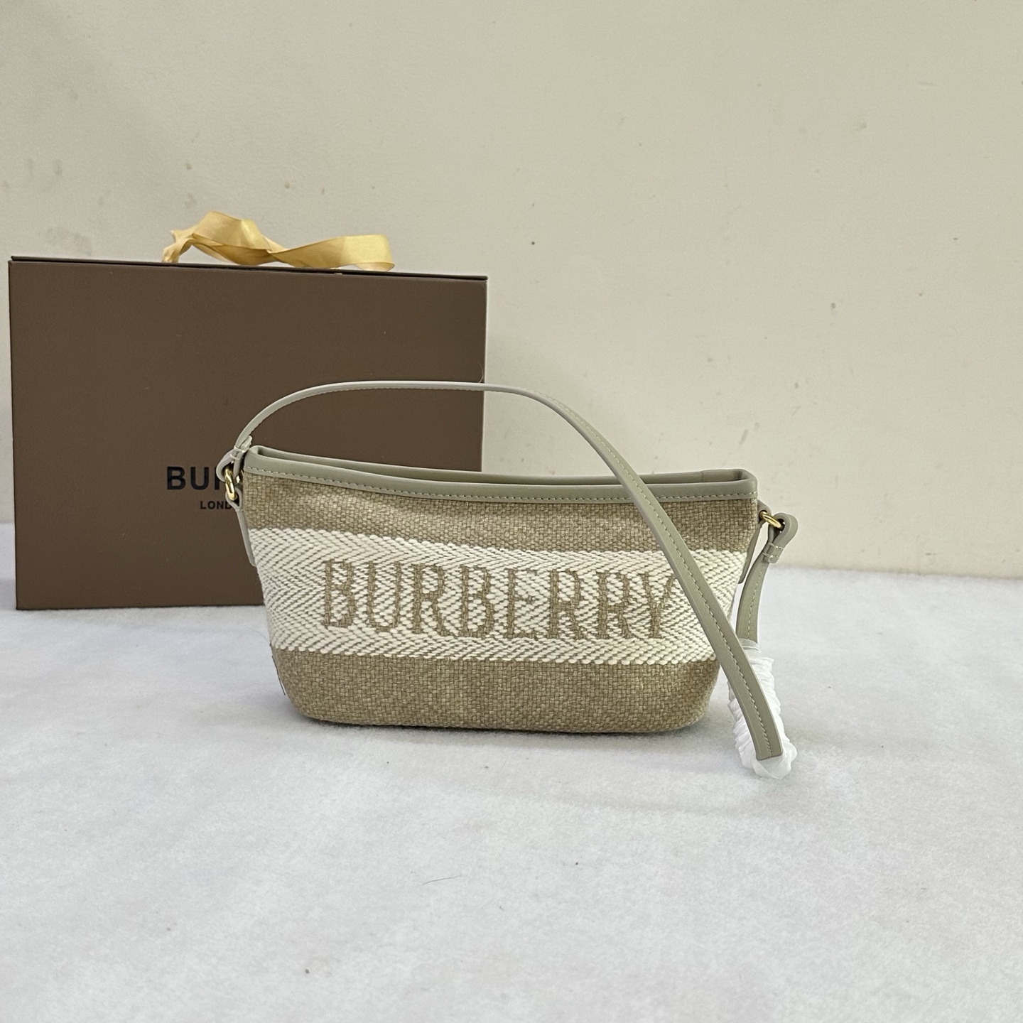 Compact shoulder bag in Burberry original logo canvas, made of linen and cotton blend fabric. Crafted in an Italian workshop, it is decorated wit