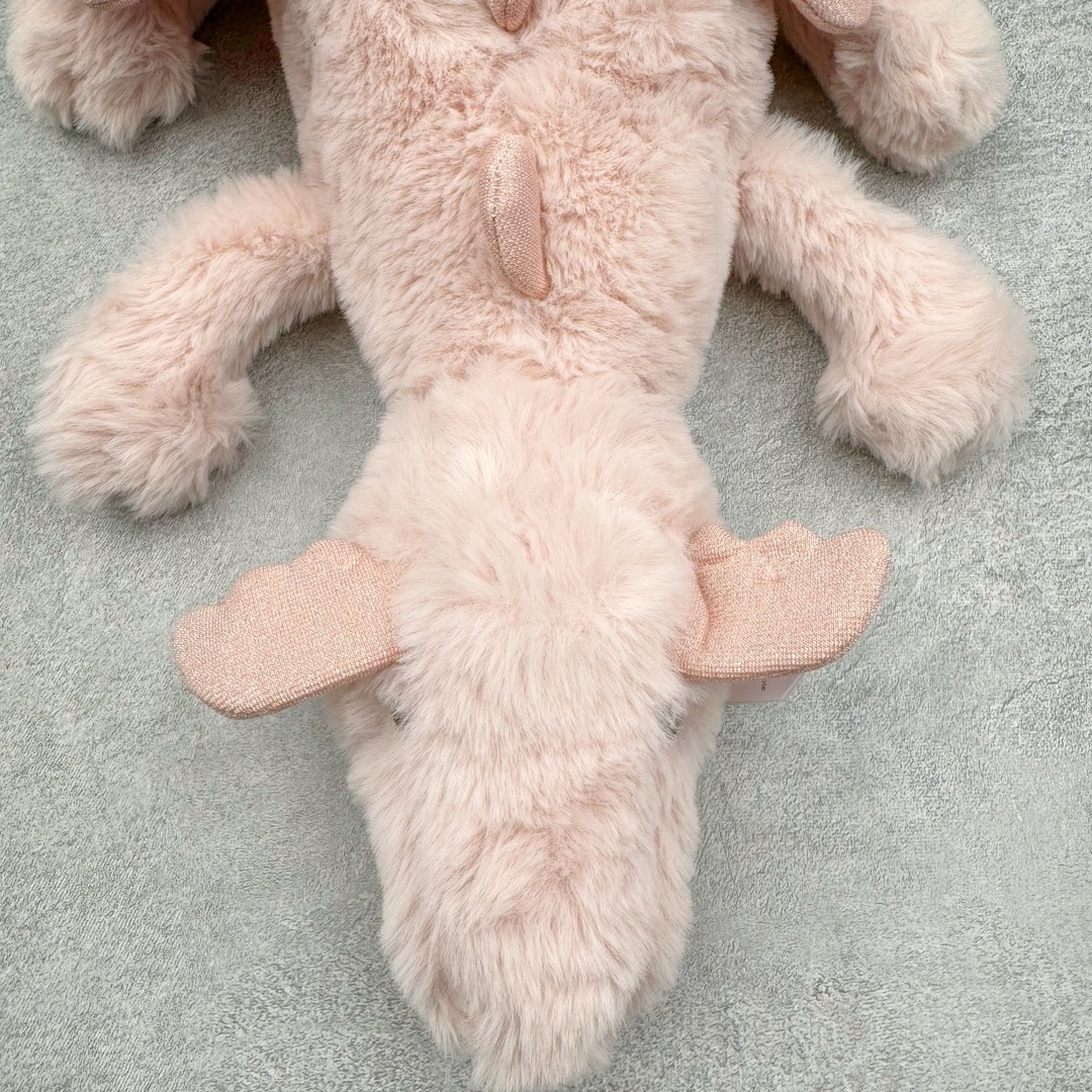 图片[4]-＃原单 Jellycat 玩偶 毛绒公仔 玫瑰色粉龙 50CM 科普：Jellycat是一个英国玩具品牌，创立于1999年，由William和Thomas兄弟二人在伦敦创立。该品牌专注于设计玩偶玩具，并全情投入于最有趣、环保和独特的软玩具领域。Jellycat的产品设计丰富且有创意，其毛绒玩具以可爱的动物形象为主打，深受全球儿童的喜爱。品牌的产品线包括各种动物系列、海洋系列、蔬果美食系列、植物系列等，每个系列都有其独特的设计和故事。Jellycat的产品设计理念是打破传统动物毛绒像动物标本一样的形象，通过改变形状、手感、颜色、大小和材料，用成千上万种方式制作一只动物毛绒。品牌的设计师来自世界各地，他们的创意让产品更具多元性，同时也让品牌能够从世界各地的文化中获得设计灵感。近年来，Jellycat品牌方开始跨界合作，与野兽派、华尔道夫酒店等品牌合作推出联名产品，进一步扩大了品牌的影响力。在社交媒体上，Jellycat也日益活跃，通过小红书、Instagram、抖音和TikTok等平台与消费者互动，分享品牌故事和产品信息。Jellycat的产品价格在99元到1699元不等，绝版产品的价格在二手平台上甚至会翻几倍。尽管有消费者认为它高价低质，价格贵、品控不严格等问题频频引来吐槽，但仍有大量粉丝愿意为“治愈”买单，因为这些毛绒玩具成为他们精神上的陪伴。原装100% polyester进口聚酯纤维面料 原厂7D棉 原单环保颗粒 双吊牌加三重水洗标 原配防尘袋 吊打市面通货 注意即使同一家厂 不同的批次面料缸差是一定都有的 官网不同批次都有 经过欧盟CE安全认证 此标准0-100岁的小朋友都适用 这个缸差和造型其实经常入手玩偶的都知道 手工制品 世上每一只jell 都是独一无二的 轻微线头 轻微不对称都是很正常的 无法避免 官网都是一样 底部走线 颗粒填充物 刺绣 走线 肉眼可见的精致 原色未染色面料纱线 超级有质感-选品中心