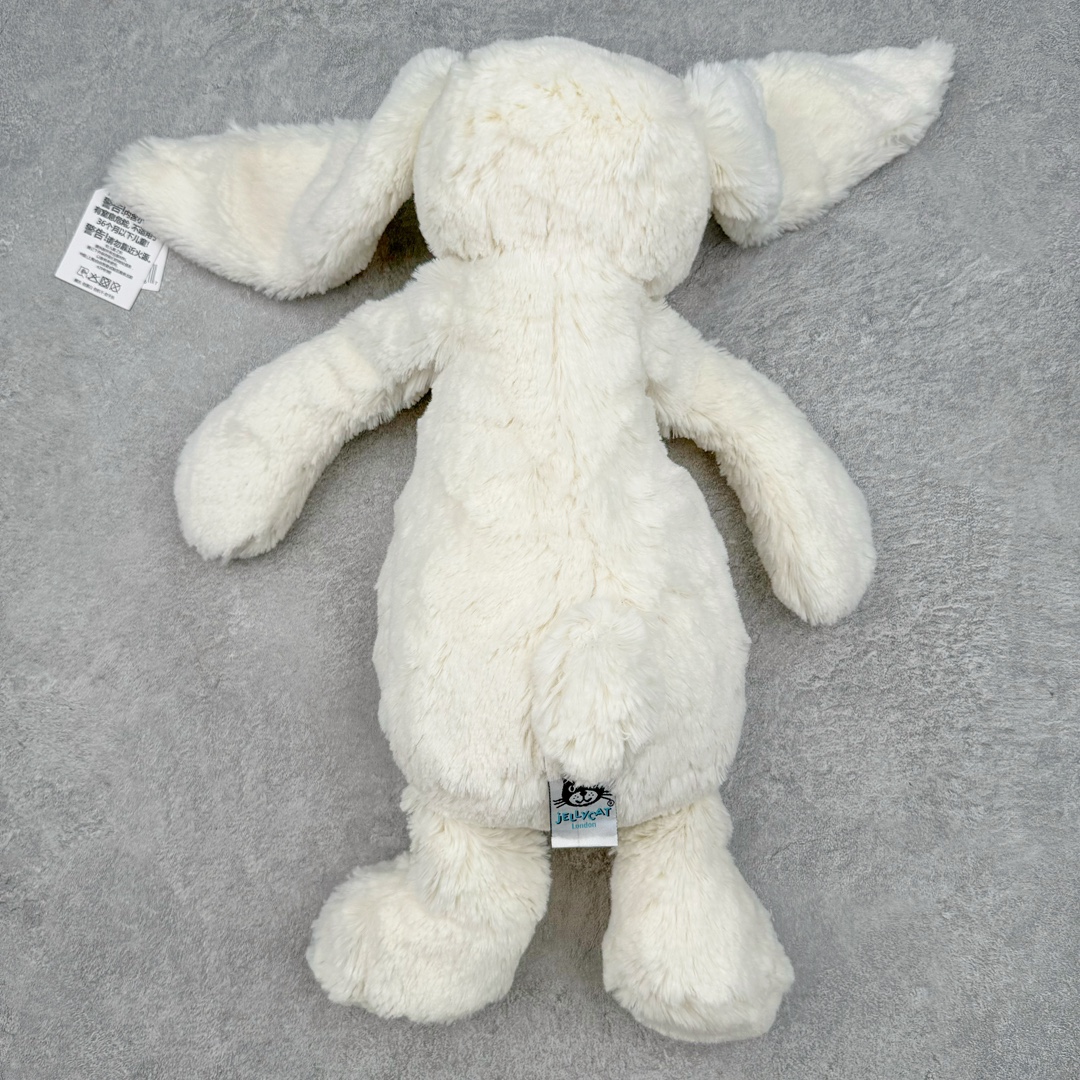 图片[2]-＃原单 Jellycat 玩偶 毛绒公仔 邦尼兔 31CM 科普：Jellycat是一个英国玩具品牌，创立于1999年，由William和Thomas兄弟二人在伦敦创立。该品牌专注于设计玩偶玩具，并全情投入于最有趣、环保和独特的软玩具领域。Jellycat的产品设计丰富且有创意，其毛绒玩具以可爱的动物形象为主打，深受全球儿童的喜爱。品牌的产品线包括各种动物系列、海洋系列、蔬果美食系列、植物系列等，每个系列都有其独特的设计和故事。Jellycat的产品设计理念是打破传统动物毛绒像动物标本一样的形象，通过改变形状、手感、颜色、大小和材料，用成千上万种方式制作一只动物毛绒。品牌的设计师来自世界各地，他们的创意让产品更具多元性，同时也让品牌能够从世界各地的文化中获得设计灵感。近年来，Jellycat品牌方开始跨界合作，与野兽派、华尔道夫酒店等品牌合作推出联名产品，进一步扩大了品牌的影响力。在社交媒体上，Jellycat也日益活跃，通过小红书、Instagram、抖音和TikTok等平台与消费者互动，分享品牌故事和产品信息。Jellycat的产品价格在99元到1699元不等，绝版产品的价格在二手平台上甚至会翻几倍。尽管有消费者认为它高价低质，价格贵、品控不严格等问题频频引来吐槽，但仍有大量粉丝愿意为“治愈”买单，因为这些毛绒玩具成为他们精神上的陪伴。原装100% polyester进口聚酯纤维面料 原厂7D棉 原单环保颗粒 双吊牌加三重水洗标 原配防尘袋 吊打市面通货 注意即使同一家厂 不同的批次面料缸差是一定都有的 官网不同批次都有 经过欧盟CE安全认证 此标准0-100岁的小朋友都适用 这个缸差和造型其实经常入手玩偶的都知道 手工制品 世上每一只jell 都是独一无二的 轻微线头 轻微不对称都是很正常的 无法避免 官网都是一样 底部走线 颗粒填充物 刺绣 走线 肉眼可见的精致 原色未染色面料纱线 超级有质感-选品中心