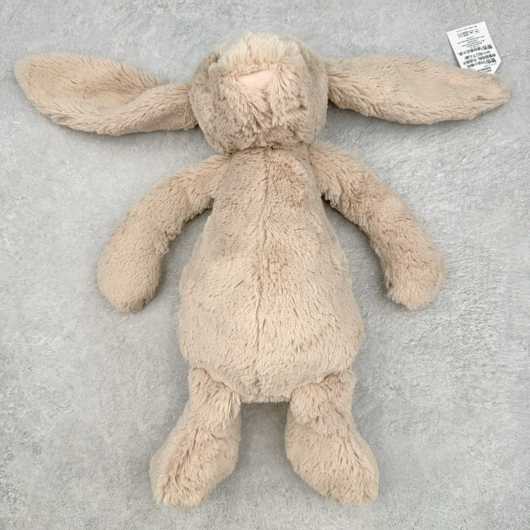 ＃原单 Jellycat 玩偶 毛绒公仔 邦尼兔 31CM 科普：Jellycat是一个英国玩具品牌，创立于1999年，由William和Thomas兄弟二人在伦敦创立。该品牌专注于设计玩偶玩具，并全情投入于最有趣、环保和独特的软玩具领域。Jellycat的产品设计丰富且有创意，其毛绒玩具以可爱的动物形象为主打，深受全球儿童的喜爱。品牌的产品线包括各种动物系列、海洋系列、蔬果美食系列、植物系列等，每个系列都有其独特的设计和故事。Jellycat的产品设计理念是打破传统动物毛绒像动物标本一样的形象，通过改变形状、手感、颜色、大小和材料，用成千上万种方式制作一只动物毛绒。品牌的设计师来自世界各地，他们的创意让产品更具多元性，同时也让品牌能够从世界各地的文化中获得设计灵感。近年来，Jellycat品牌方开始跨界合作，与野兽派、华尔道夫酒店等品牌合作推出联名产品，进一步扩大了品牌的影响力。在社交媒体上，Jellycat也日益活跃，通过小红书、Instagram、抖音和TikTok等平台与消费者互动，分享品牌故事和产品信息。Jellycat的产品价格在99元到1699元不等，绝版产品的价格在二手平台上甚至会翻几倍。尽管有消费者认为它高价低质，价格贵、品控不严格等问题频频引来吐槽，但仍有大量粉丝愿意为“治愈”买单，因为这些毛绒玩具成为他们精神上的陪伴。原装100% polyester进口聚酯纤维面料 原厂7D棉 原单环保颗粒 双吊牌加三重水洗标 原配防尘袋 吊打市面通货 注意即使同一家厂 不同的批次面料缸差是一定都有的 官网不同批次都有 经过欧盟CE安全认证 此标准0-100岁的小朋友都适用 这个缸差和造型其实经常入手玩偶的都知道 手工制品 世上每一只jell 都是独一无二的 轻微线头 轻微不对称都是很正常的 无法避免 官网都是一样 底部走线 颗粒填充物 刺绣 走线 肉眼可见的精致 原色未染色面料纱线 超级有质感-选品中心