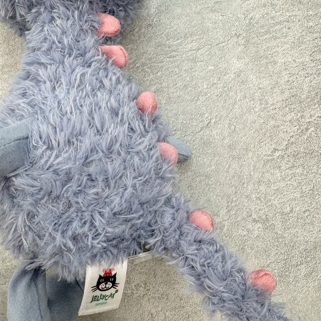 图片[7]-＃原单 Jellycat 玩偶 毛绒公仔 比米小怪兽 26CM 科普：Jellycat是一个英国玩具品牌，创立于1999年，由William和Thomas兄弟二人在伦敦创立。该品牌专注于设计玩偶玩具，并全情投入于最有趣、环保和独特的软玩具领域。Jellycat的产品设计丰富且有创意，其毛绒玩具以可爱的动物形象为主打，深受全球儿童的喜爱。品牌的产品线包括各种动物系列、海洋系列、蔬果美食系列、植物系列等，每个系列都有其独特的设计和故事。Jellycat的产品设计理念是打破传统动物毛绒像动物标本一样的形象，通过改变形状、手感、颜色、大小和材料，用成千上万种方式制作一只动物毛绒。品牌的设计师来自世界各地，他们的创意让产品更具多元性，同时也让品牌能够从世界各地的文化中获得设计灵感。近年来，Jellycat品牌方开始跨界合作，与野兽派、华尔道夫酒店等品牌合作推出联名产品，进一步扩大了品牌的影响力。在社交媒体上，Jellycat也日益活跃，通过小红书、Instagram、抖音和TikTok等平台与消费者互动，分享品牌故事和产品信息。Jellycat的产品价格在99元到1699元不等，绝版产品的价格在二手平台上甚至会翻几倍。尽管有消费者认为它高价低质，价格贵、品控不严格等问题频频引来吐槽，但仍有大量粉丝愿意为“治愈”买单，因为这些毛绒玩具成为他们精神上的陪伴。原装100% polyester进口聚酯纤维面料 原厂7D棉 原单环保颗粒 双吊牌加三重水洗标 原配防尘袋 吊打市面通货 注意即使同一家厂 不同的批次面料缸差是一定都有的 官网不同批次都有 经过欧盟CE安全认证 此标准0-100岁的小朋友都适用 这个缸差和造型其实经常入手玩偶的都知道 手工制品 世上每一只jell 都是独一无二的 轻微线头 轻微不对称都是很正常的 无法避免 官网都是一样 底部走线 颗粒填充物 刺绣 走线 肉眼可见的精致 原色未染色面料纱线 超级有质感-选品中心