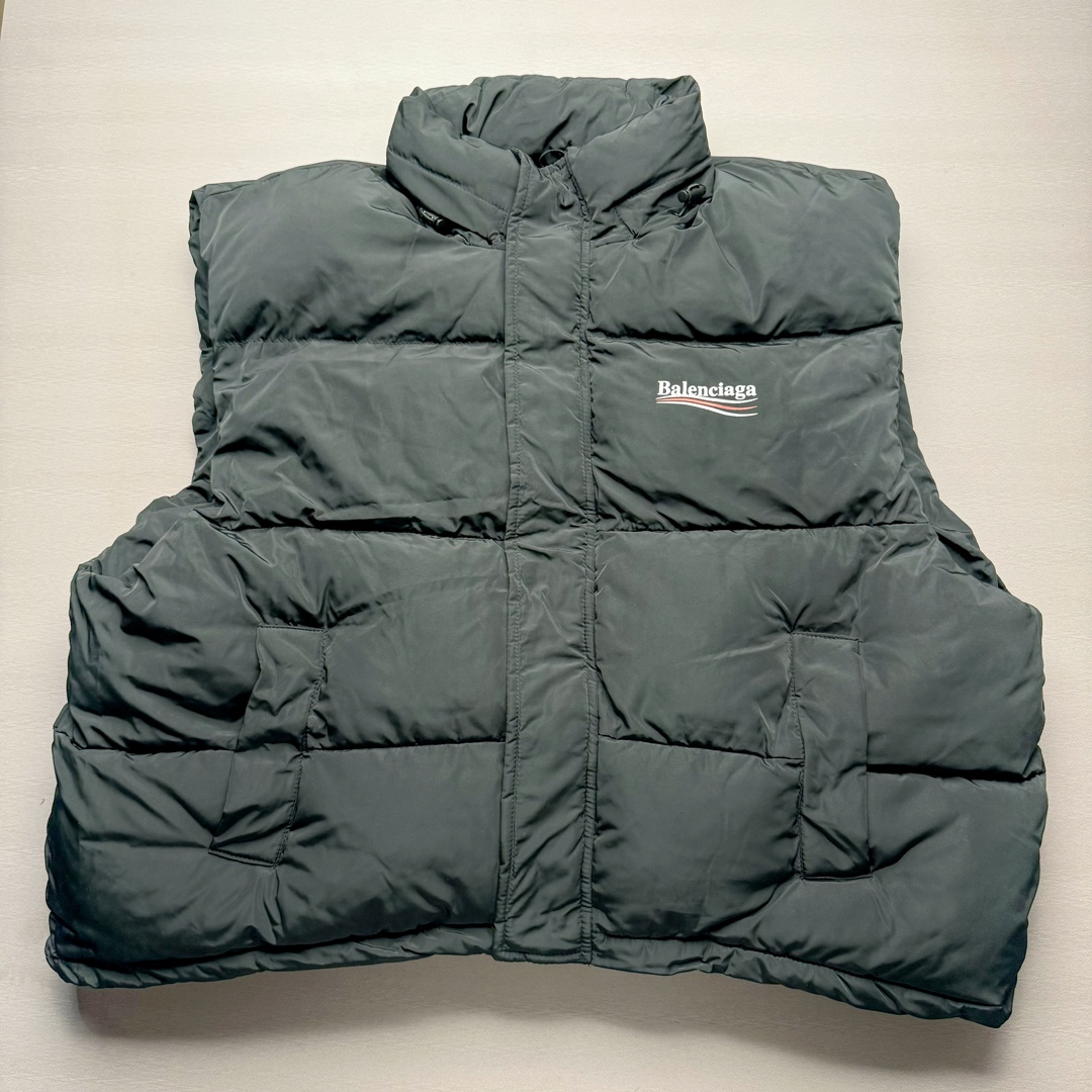 Balenciaga FW23 巴黎世家可乐Logo印花立领马甲常规版型 原版第一时间2.2w购入开发工艺说明 前短后长设计 胸前经典可乐印花logo 特殊剪裁后背呈龟壳型 内里搭配内袋设计 走线平直 正面人工定位裁剪按扣前袋 做旧五金纽扣 logo刻纹清晰 面料纹路与质感都完美还原 隐藏式拉链按扣前襟 下摆搭配双孔松紧扣 整体多工艺结合 做工精细 每一处细节都严格遵循原版 背后可乐海浪logo先胚布做成成衣 采用高功率冷融印花 再后整熨烫 肩袖缝合处走线密实 面料订织订染 面布采用防水涂层科技工艺 表面布防水不易污 胆布采用保暖科技面料 高领设计 隐藏式按扣 可折叠抽绳兜帽 整体采用3D立体剪裁 还原砖柜品质 尺码：42 44 46-选品中心