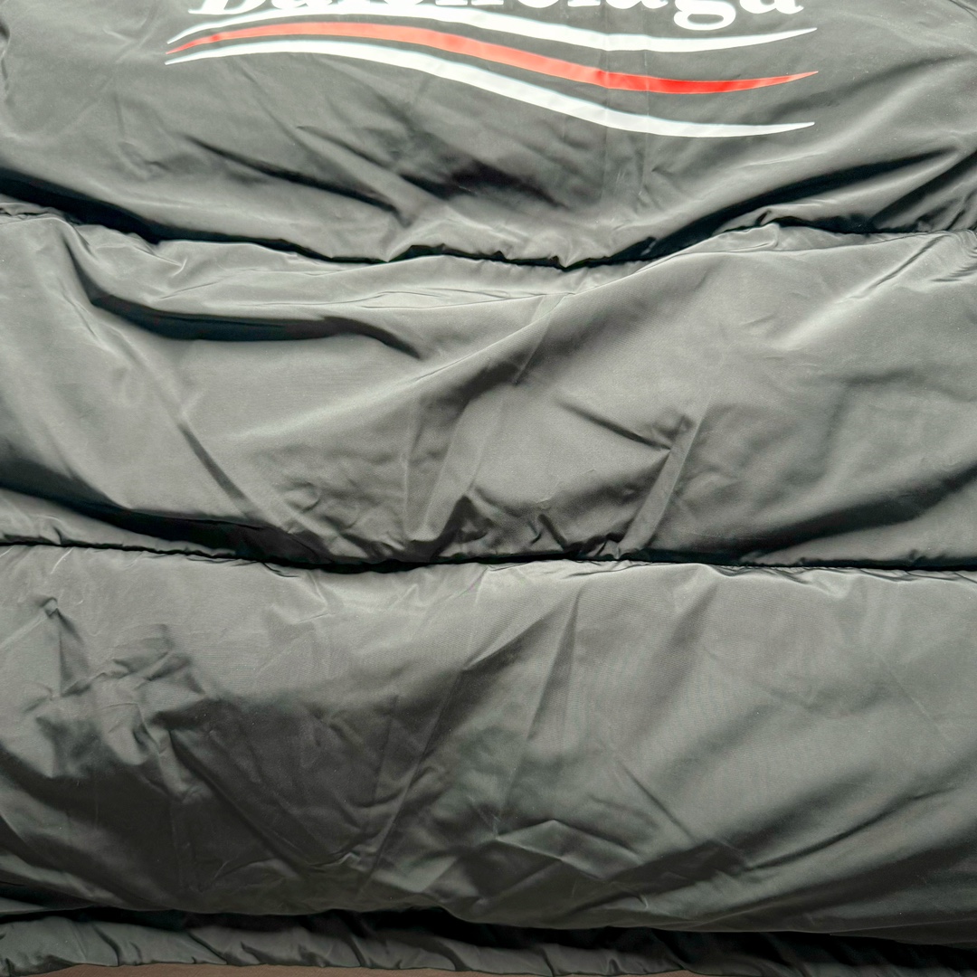 图片[10]-Balenciaga FW23 巴黎世家可乐Logo印花立领马甲常规版型 原版第一时间2.2w购入开发工艺说明 前短后长设计 胸前经典可乐印花logo 特殊剪裁后背呈龟壳型 内里搭配内袋设计 走线平直 正面人工定位裁剪按扣前袋 做旧五金纽扣 logo刻纹清晰 面料纹路与质感都完美还原 隐藏式拉链按扣前襟 下摆搭配双孔松紧扣 整体多工艺结合 做工精细 每一处细节都严格遵循原版 背后可乐海浪logo先胚布做成成衣 采用高功率冷融印花 再后整熨烫 肩袖缝合处走线密实 面料订织订染 面布采用防水涂层科技工艺 表面布防水不易污 胆布采用保暖科技面料 高领设计 隐藏式按扣 可折叠抽绳兜帽 整体采用3D立体剪裁 还原砖柜品质 尺码：42 44 46-选品中心