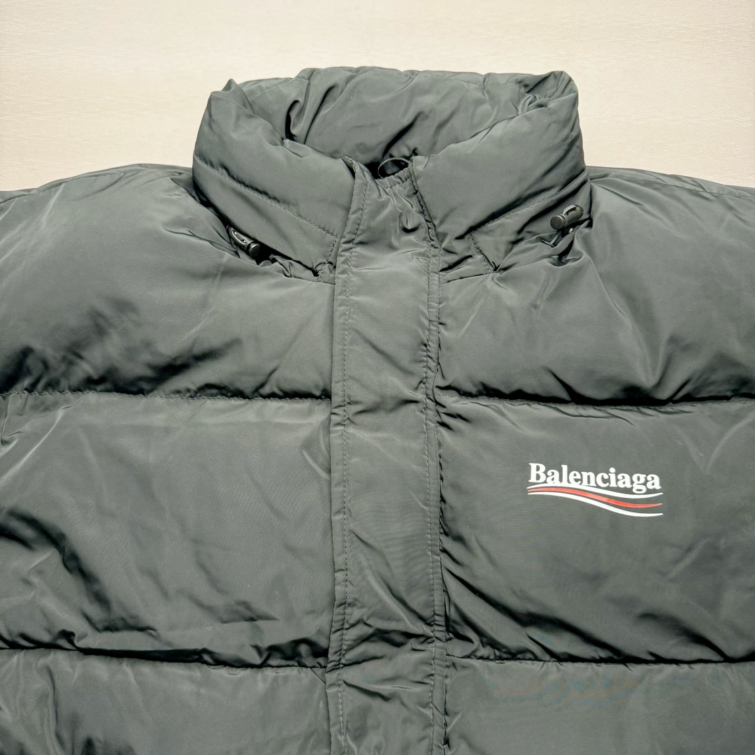 图片[4]-Balenciaga FW23 巴黎世家可乐Logo印花立领马甲常规版型 原版第一时间2.2w购入开发工艺说明 前短后长设计 胸前经典可乐印花logo 特殊剪裁后背呈龟壳型 内里搭配内袋设计 走线平直 正面人工定位裁剪按扣前袋 做旧五金纽扣 logo刻纹清晰 面料纹路与质感都完美还原 隐藏式拉链按扣前襟 下摆搭配双孔松紧扣 整体多工艺结合 做工精细 每一处细节都严格遵循原版 背后可乐海浪logo先胚布做成成衣 采用高功率冷融印花 再后整熨烫 肩袖缝合处走线密实 面料订织订染 面布采用防水涂层科技工艺 表面布防水不易污 胆布采用保暖科技面料 高领设计 隐藏式按扣 可折叠抽绳兜帽 整体采用3D立体剪裁 还原砖柜品质 尺码：42 44 46-选品中心