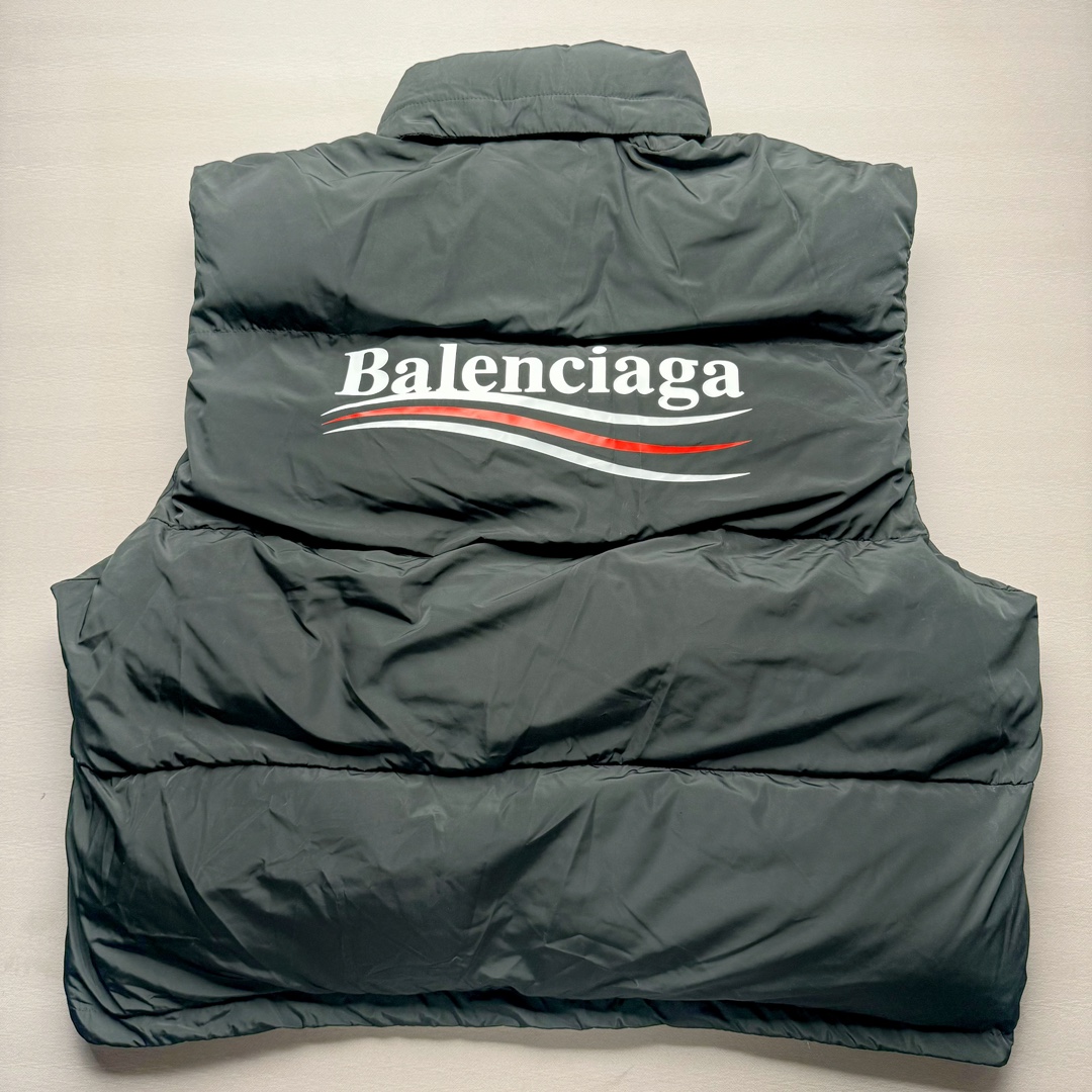 图片[2]-Balenciaga FW23 巴黎世家可乐Logo印花立领马甲常规版型 原版第一时间2.2w购入开发工艺说明 前短后长设计 胸前经典可乐印花logo 特殊剪裁后背呈龟壳型 内里搭配内袋设计 走线平直 正面人工定位裁剪按扣前袋 做旧五金纽扣 logo刻纹清晰 面料纹路与质感都完美还原 隐藏式拉链按扣前襟 下摆搭配双孔松紧扣 整体多工艺结合 做工精细 每一处细节都严格遵循原版 背后可乐海浪logo先胚布做成成衣 采用高功率冷融印花 再后整熨烫 肩袖缝合处走线密实 面料订织订染 面布采用防水涂层科技工艺 表面布防水不易污 胆布采用保暖科技面料 高领设计 隐藏式按扣 可折叠抽绳兜帽 整体采用3D立体剪裁 还原砖柜品质 尺码：42 44 46-选品中心