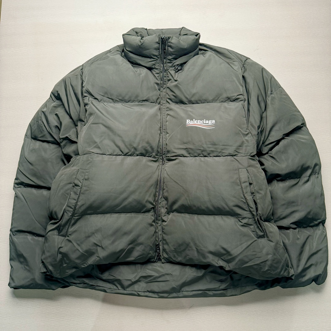 Balenciaga FW23 巴黎世家可乐字母Logo印花长袖夹克宽松版型面包服 原版原价1.58w购入开发面料采用防水风衣面料 里布采用人造丝斜纹布 做防水涂层工艺手感立体丝滑带有功能性 内里夹层棉采用 1500目洗水棉大身跟袖子按照比例车缝走线分格型 整件衣服采用定位花+前幅门襟还原花纯手工剪裁 配套开模订制带BA字母四合扣+鸡眼 黑色款配呛色铝合金材质 前幅门襟拉链 帽檐配全套联名辅料 尺码：42 44 46-选品中心