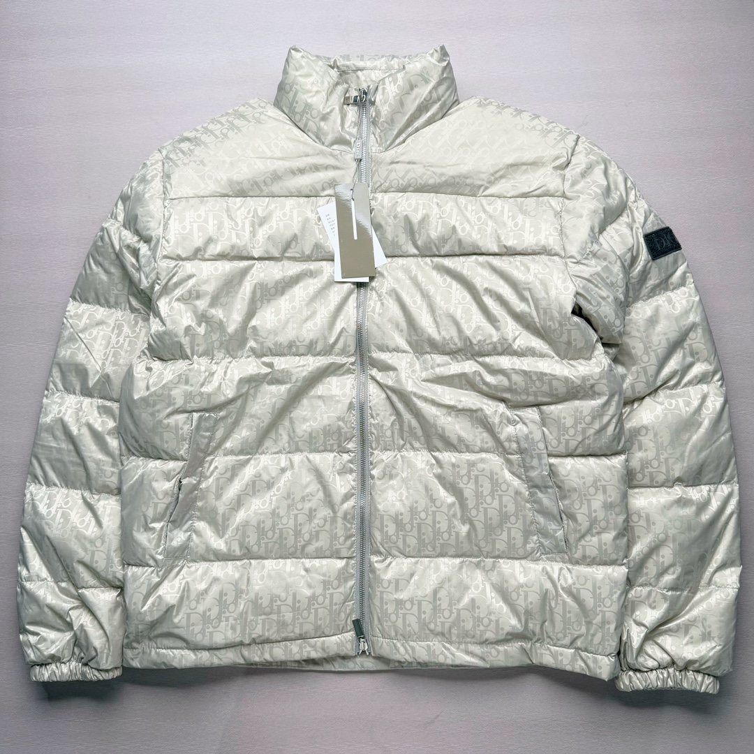 DIOR 23SS 迪奥新品满印暗纹老花立领羽绒服夹克 原24000购入 全衣面料采用原厂进口科技GORE-TEX提花面料 菱形印花图案设计间距及细节间距平行对位 并列的提花效果及手感非常还原 内里填充物采用国标级别90度 里料附层锦纶材质 蓬松度的白鹅绒混白鹅毛的材质 羽绒蓬感十足 保暖效果更佳 没有羽绒毛梗 利落的小立领搭配合肩线 肩前幅侧画增添了的双口袋设计 下摆设有抽绳可自由调节松紧、袖口带有松紧橡筋收口、门襟双开立领设计 镀银刻字五金配件搭配高品质欧牙双向拉链开合 拉头、鸡眼、内袋扣、暗扣、调节扣等依旧原版开模带Logo定制而成 尺码：46 48 50 52 54-选品中心