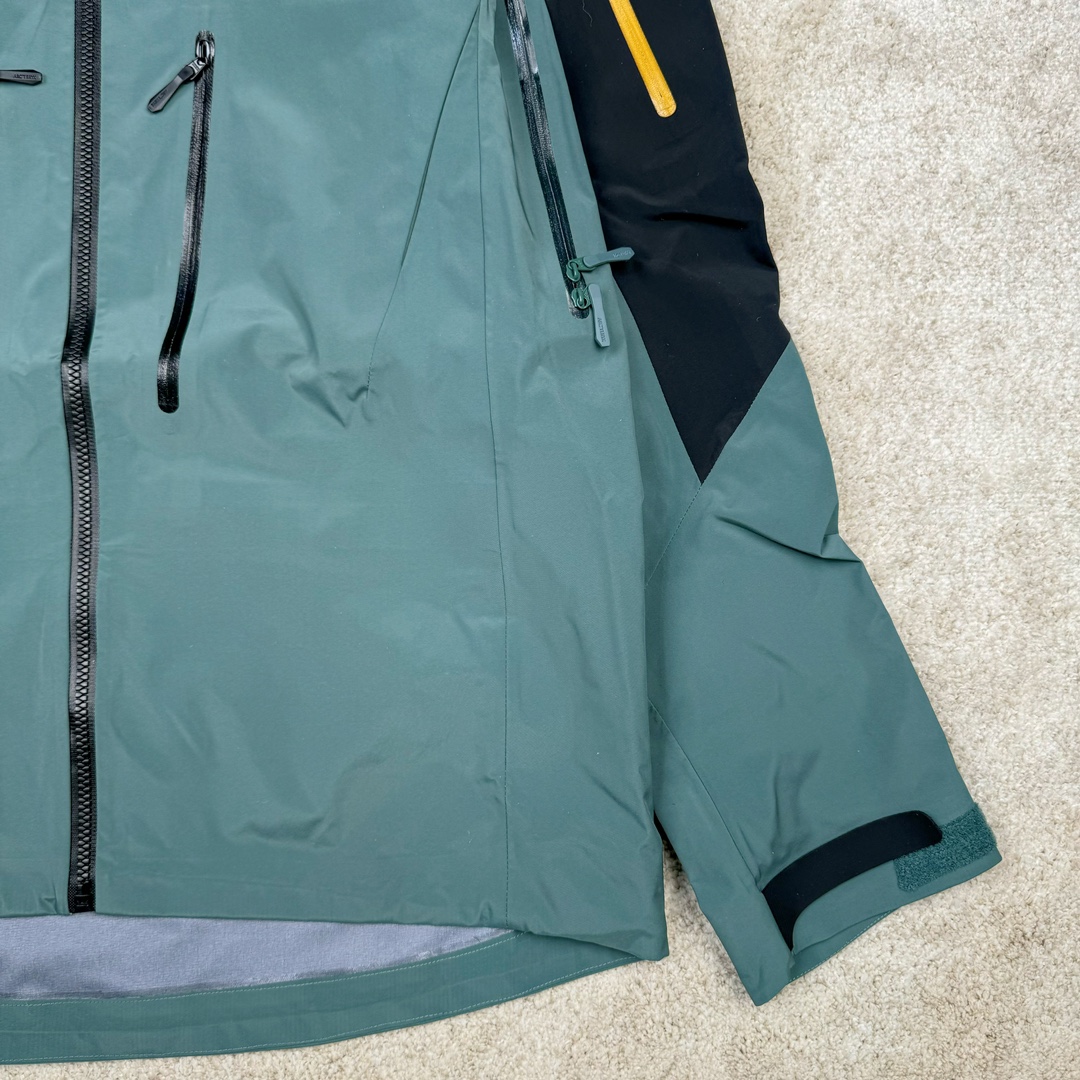 图片[7]-＃TZD Arcteryx Alpha SV 7 GORE-TEX Pro 始祖鸟第七代刺绣Logo图案休闲运动连帽拉链硬壳户外远足防水冲锋衣 台州顶级批次 现货供应 针对严酷的户外环境而设计 旨在为运动爱好者提供终极的保护 定制Bluesign认证的采用带经编背衬N40 P 3 LGORE-TEX面料 轻薄而耐磨，防风、防水且透气 三层复合 在高摩擦和易损坏的部位进行了加固处理 依照鸟核心科技E3D修身剪裁 整衣3D立体仿生学设计衣长臂弯 符合人体工程学剪裁原理 运动自如 采用YKK防水拉链 需要专业机器激光切割的弧形再用防水拉链热压合缝 定制拉链绳无色差竖纹打枣 刺绣采用进口TAJIMA机台加工 进口百灵达刺绣机器立体饱满 内膜高温压胶工艺 工人一小时才能压一件 做工精细全套辅料开模定制 水洗标吊卡齐全压胶工艺 带弹性帽沿锋帽 头盔兼容式风雪帽 兼容头盔视线自由单手可调节树脂拉链，加长孤形下摆 弹力设计 克防止寒气入侵等极端天气 锁住头部温度 轻便防水舒适柔软 这是鸟的匠心之作徒步系列从面料到做工细节都无可挑剔 尺码：S M L XL XXL-选品中心