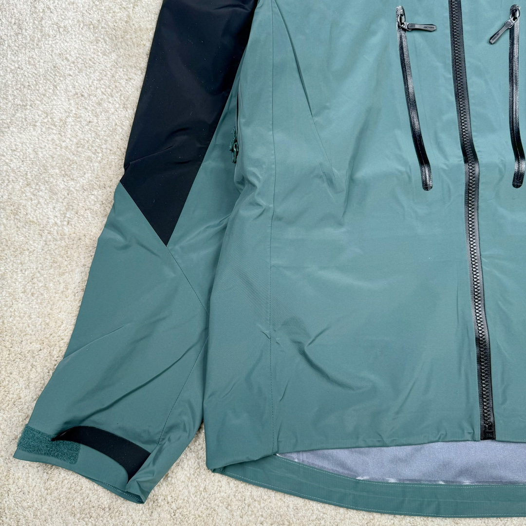 图片[6]-＃TZD Arcteryx Alpha SV 7 GORE-TEX Pro 始祖鸟第七代刺绣Logo图案休闲运动连帽拉链硬壳户外远足防水冲锋衣 台州顶级批次 现货供应 针对严酷的户外环境而设计 旨在为运动爱好者提供终极的保护 定制Bluesign认证的采用带经编背衬N40 P 3 LGORE-TEX面料 轻薄而耐磨，防风、防水且透气 三层复合 在高摩擦和易损坏的部位进行了加固处理 依照鸟核心科技E3D修身剪裁 整衣3D立体仿生学设计衣长臂弯 符合人体工程学剪裁原理 运动自如 采用YKK防水拉链 需要专业机器激光切割的弧形再用防水拉链热压合缝 定制拉链绳无色差竖纹打枣 刺绣采用进口TAJIMA机台加工 进口百灵达刺绣机器立体饱满 内膜高温压胶工艺 工人一小时才能压一件 做工精细全套辅料开模定制 水洗标吊卡齐全压胶工艺 带弹性帽沿锋帽 头盔兼容式风雪帽 兼容头盔视线自由单手可调节树脂拉链，加长孤形下摆 弹力设计 克防止寒气入侵等极端天气 锁住头部温度 轻便防水舒适柔软 这是鸟的匠心之作徒步系列从面料到做工细节都无可挑剔 尺码：S M L XL XXL-选品中心