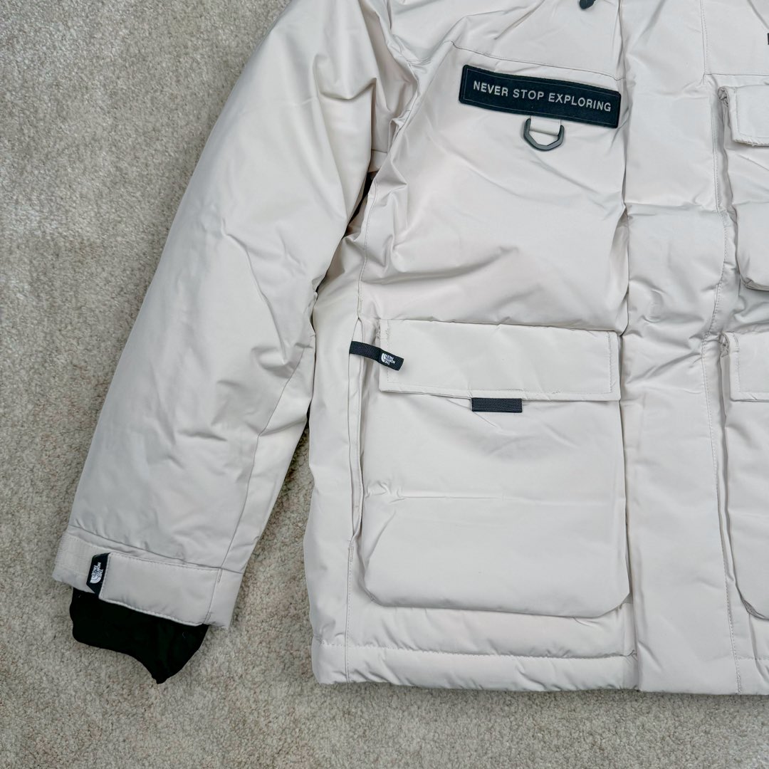 图片[6]-北面THE NORTH FACE POLAR FW22 纯色Logo徽标多口袋抽绳厚款连帽工装羽绒服冬季 男女同款 申敏儿同款 设计理念： 这款是THE NORTH FACE 巅峰之作，高端于任何一款北面羽绒服，也是户外的登山系列，爆炸厚实，一般是在户外极寒天气穿着，基本上可以抵御零下几十度的严寒了，工艺十分复杂，并非单纯一件羽绒服那么简单，保暖程度不输大鹅，今年冬天一定需要这样一件厚实的过冬。 面料+特点： ✅ 内里填充90%正品一致的进口专用鹅绒，轻便，100%市面最高品质。 ✅ 采用经联盟RDS认证的高品质鹅绒填充，轻便不厚重且压缩后的蓬松度恢复性好。（ R·D·S不含任何不必要的动物伤害生产工序，从550蓬到950蓬不等，压缩性和温度重量也是衡量高品质，高填充度鹅线要指标） ✅单件成品1公斤以上，但是没有任何负重感，超级轻便，鹅绒广泛用于滑雪服，防寒服。 ✅原厂高密度户外防水材质，防风耐磨，防撕裂面料。 ✅ 里布380T最高标准，绝不跑绒，透气性极佳 ✅ 原版辅料五金全部原厂定做，100%还原复刻品质！ ✅多功能口袋，方便使用 ✅内里两侧印有保养清洗说明和衣服解释 ✅胸前贴饰有橡胶徽标logo ✅领口部分有防寒绒布，紧贴头颈，舒适又保暖 ✅ 原版辅料五金全部原厂定做，100%还原复刻品质，背部有内置网口袋 ✅ YKK吉田ISO9000品质顶级ZP拉链 工艺： 宽松版型，上身休闲舒适，为冬季户外提供保暖呵护，保暖性出色，穿着轻便不厚重。防潮,不易变形 ，容易清洁打理等特点，工艺成本极高 ​-选品中心