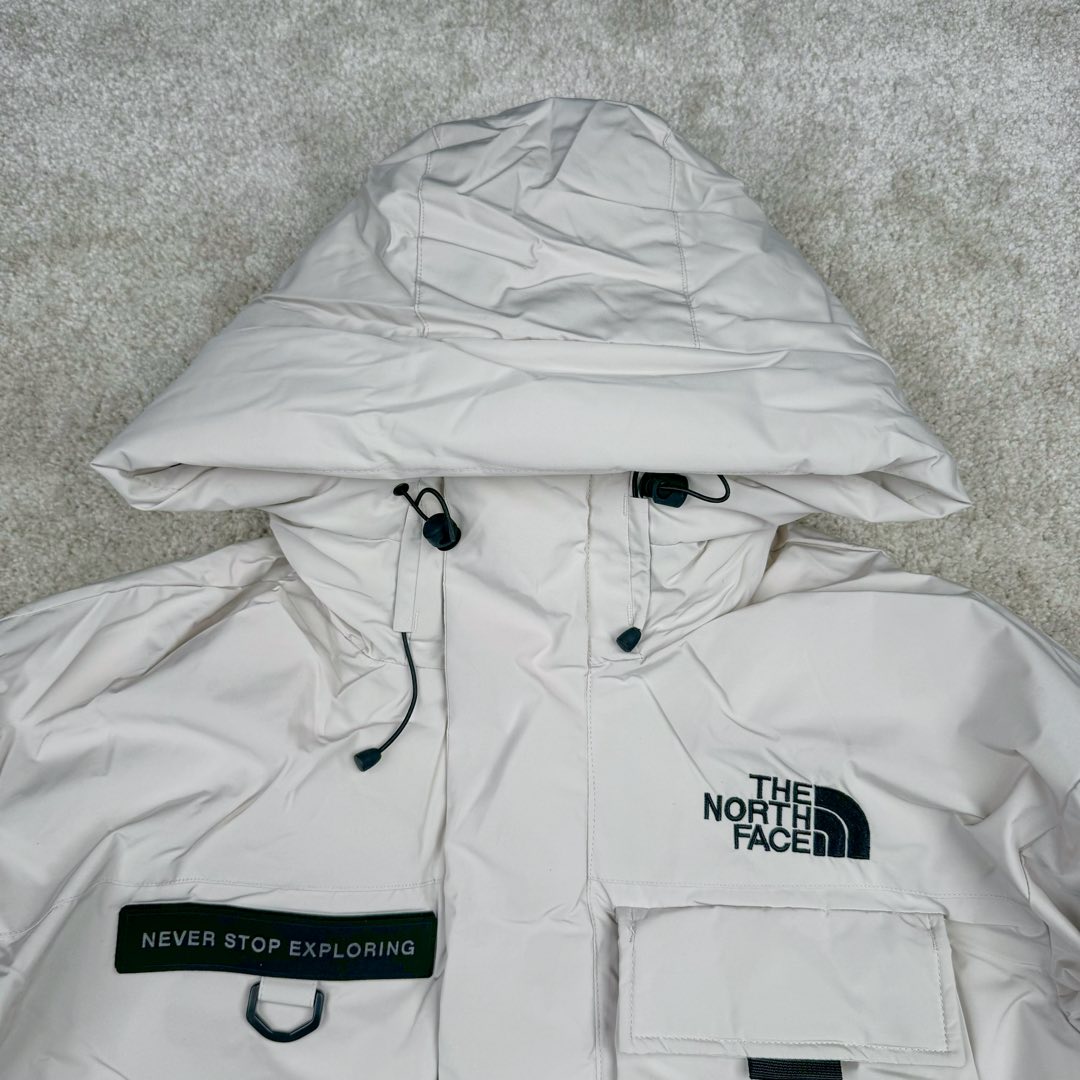 图片[4]-北面THE NORTH FACE POLAR FW22 纯色Logo徽标多口袋抽绳厚款连帽工装羽绒服冬季 男女同款 申敏儿同款 设计理念： 这款是THE NORTH FACE 巅峰之作，高端于任何一款北面羽绒服，也是户外的登山系列，爆炸厚实，一般是在户外极寒天气穿着，基本上可以抵御零下几十度的严寒了，工艺十分复杂，并非单纯一件羽绒服那么简单，保暖程度不输大鹅，今年冬天一定需要这样一件厚实的过冬。 面料+特点： ✅ 内里填充90%正品一致的进口专用鹅绒，轻便，100%市面最高品质。 ✅ 采用经联盟RDS认证的高品质鹅绒填充，轻便不厚重且压缩后的蓬松度恢复性好。（ R·D·S不含任何不必要的动物伤害生产工序，从550蓬到950蓬不等，压缩性和温度重量也是衡量高品质，高填充度鹅线要指标） ✅单件成品1公斤以上，但是没有任何负重感，超级轻便，鹅绒广泛用于滑雪服，防寒服。 ✅原厂高密度户外防水材质，防风耐磨，防撕裂面料。 ✅ 里布380T最高标准，绝不跑绒，透气性极佳 ✅ 原版辅料五金全部原厂定做，100%还原复刻品质！ ✅多功能口袋，方便使用 ✅内里两侧印有保养清洗说明和衣服解释 ✅胸前贴饰有橡胶徽标logo ✅领口部分有防寒绒布，紧贴头颈，舒适又保暖 ✅ 原版辅料五金全部原厂定做，100%还原复刻品质，背部有内置网口袋 ✅ YKK吉田ISO9000品质顶级ZP拉链 工艺： 宽松版型，上身休闲舒适，为冬季户外提供保暖呵护，保暖性出色，穿着轻便不厚重。防潮,不易变形 ，容易清洁打理等特点，工艺成本极高 ​-选品中心