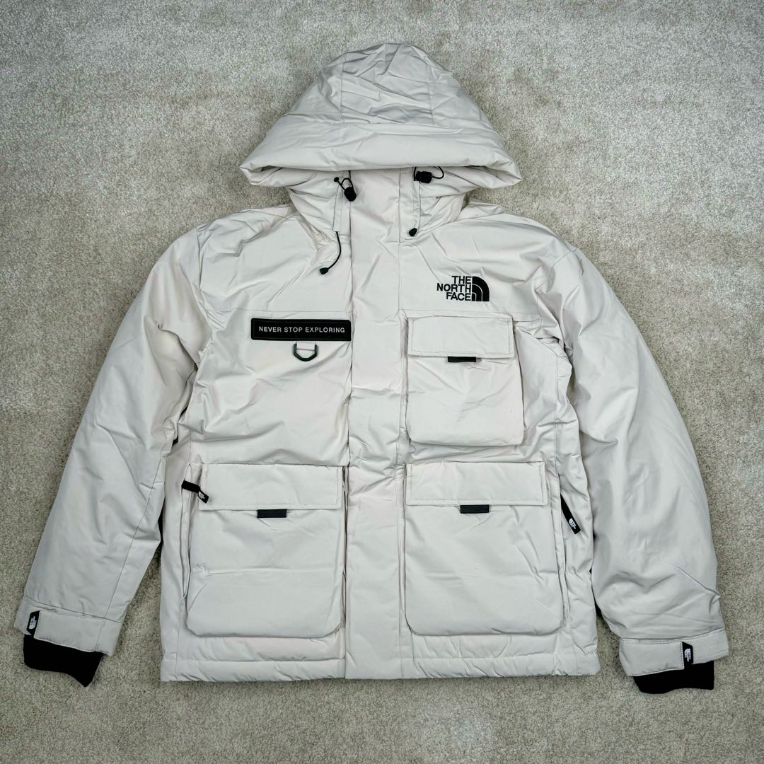 北面THE NORTH FACE POLAR FW22 纯色Logo徽标多口袋抽绳厚款连帽工装羽绒服冬季 男女同款 申敏儿同款 设计理念： 这款是THE NORTH FACE 巅峰之作，高端于任何一款北面羽绒服，也是户外的登山系列，爆炸厚实，一般是在户外极寒天气穿着，基本上可以抵御零下几十度的严寒了，工艺十分复杂，并非单纯一件羽绒服那么简单，保暖程度不输大鹅，今年冬天一定需要这样一件厚实的过冬。 面料+特点： ✅ 内里填充90%正品一致的进口专用鹅绒，轻便，100%市面最高品质。 ✅ 采用经联盟RDS认证的高品质鹅绒填充，轻便不厚重且压缩后的蓬松度恢复性好。（ R·D·S不含任何不必要的动物伤害生产工序，从550蓬到950蓬不等，压缩性和温度重量也是衡量高品质，高填充度鹅线要指标） ✅单件成品1公斤以上，但是没有任何负重感，超级轻便，鹅绒广泛用于滑雪服，防寒服。 ✅原厂高密度户外防水材质，防风耐磨，防撕裂面料。 ✅ 里布380T最高标准，绝不跑绒，透气性极佳 ✅ 原版辅料五金全部原厂定做，100%还原复刻品质！ ✅多功能口袋，方便使用 ✅内里两侧印有保养清洗说明和衣服解释 ✅胸前贴饰有橡胶徽标logo ✅领口部分有防寒绒布，紧贴头颈，舒适又保暖 ✅ 原版辅料五金全部原厂定做，100%还原复刻品质，背部有内置网口袋 ✅ YKK吉田ISO9000品质顶级ZP拉链 工艺： 宽松版型，上身休闲舒适，为冬季户外提供保暖呵护，保暖性出色，穿着轻便不厚重。防潮,不易变形 ，容易清洁打理等特点，工艺成本极高 ​-选品中心