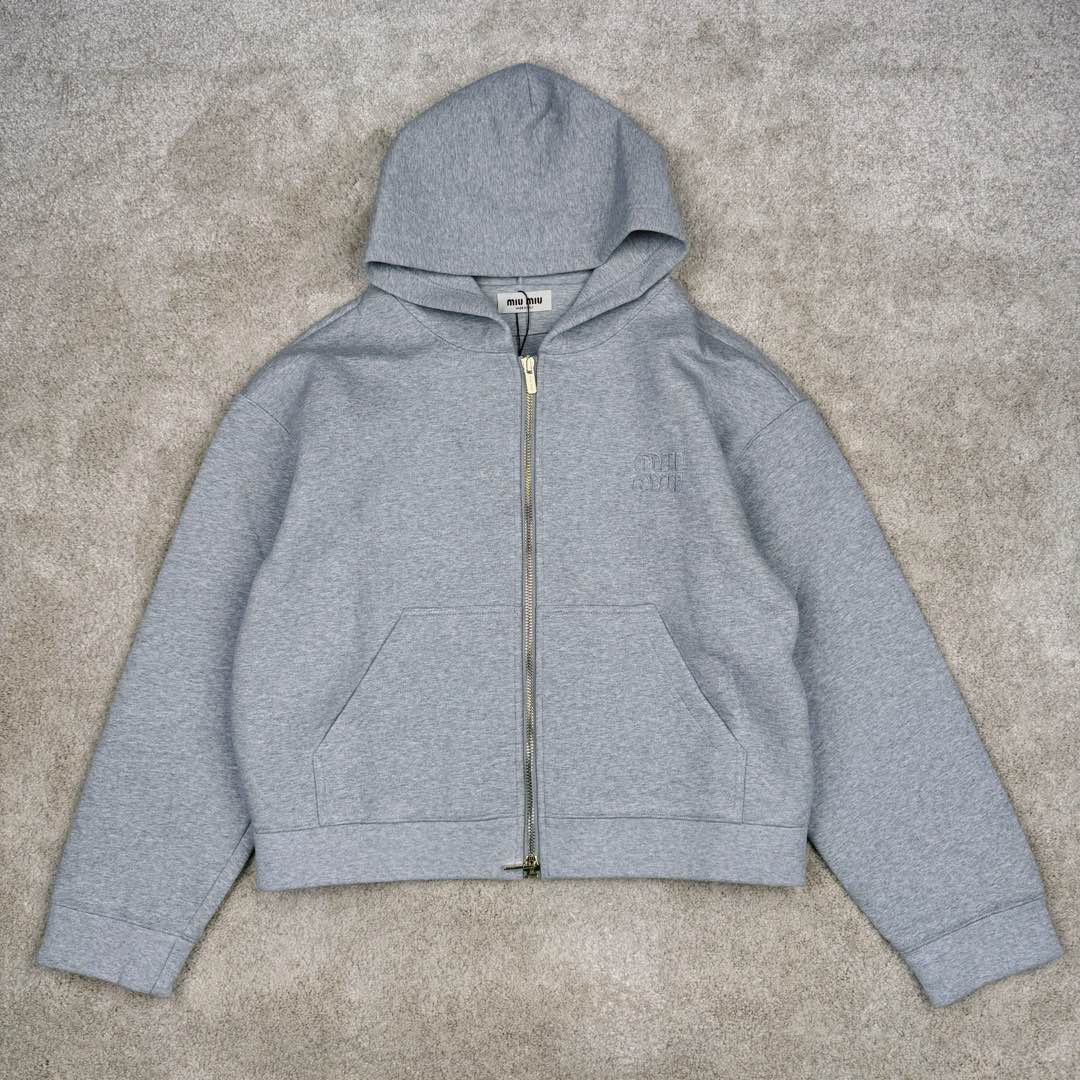 MIU MIU SS23 缪缪连帽拉链纯色长袖夹克 灰色 17400太古汇购入 研发半年为了做这款衣服自购一台特种机 市场其他所有版本miumiu缝线都不整齐或者使用激光烧花 激光烧花工艺会导致面料边发黄发硬 此件面料采用三层工艺 主面料380克重定制花灰纯棉 复合280克反面内里 中间使用100克布帛衔接 整件克重达到760 拉链采用瑞士牙riri拉链 非常昂贵 内里领口 侧面 下摆全部手工走线 市场版本这三个地方全是简化工艺 整件衣服非常重工 出货非常难 春款仅一批不再补货 手慢无 尺码：S M L XL-选品中心