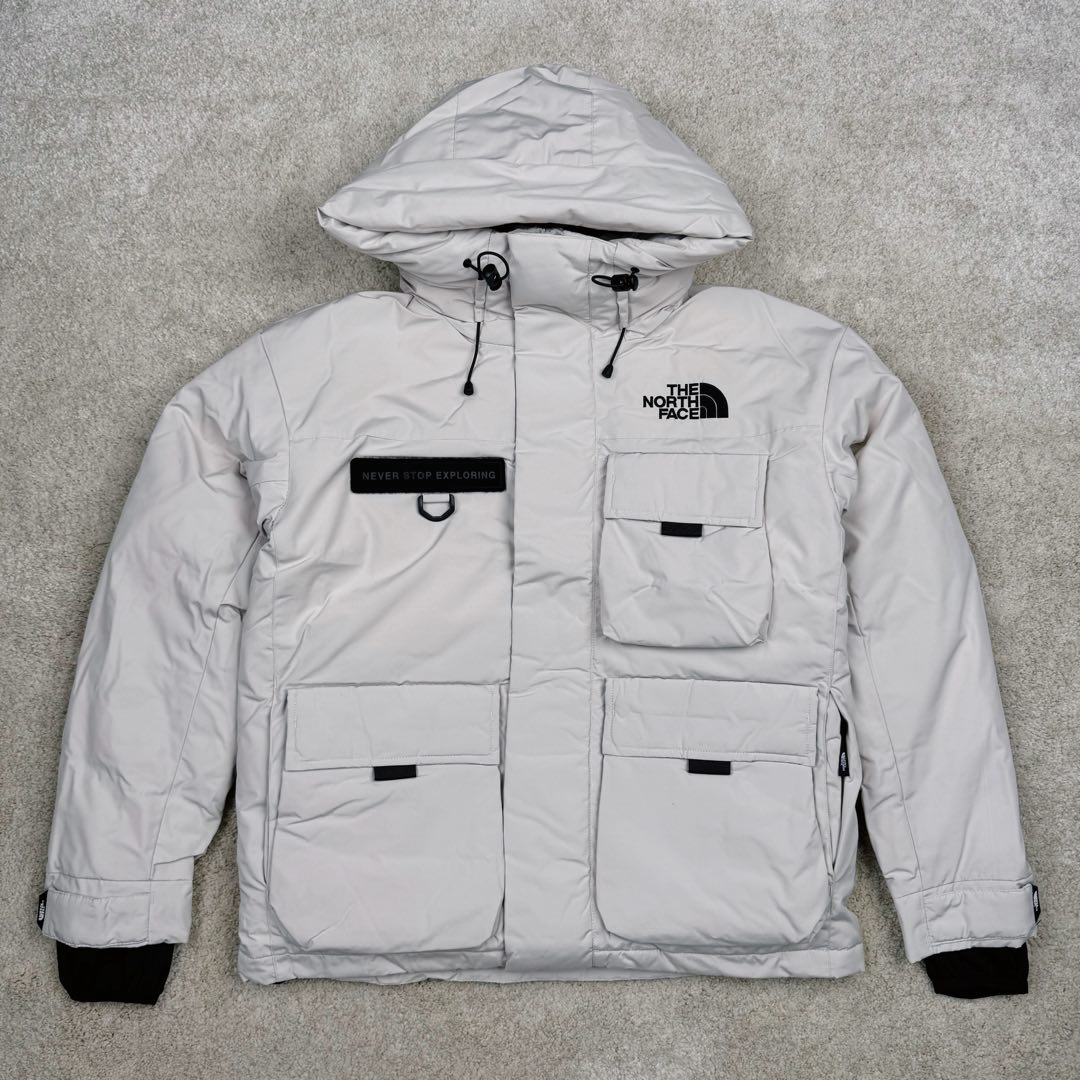＃暖冬福利 北面THE NORTH FACE POLAR FW22 纯色Logo徽标多口袋抽绳厚款连帽工装羽绒服冬季 男女同款 申敏儿同款 设计理念： 这款是THE NORTH FACE 巅峰之作，高端于任何一款北面羽绒服，也是户外的登山系列，爆炸厚实，一般是在户外极寒天气穿着，基本上可以抵御零下几十度的严寒了，工艺十分复杂，并非单纯一件羽绒服那么简单，保暖程度不输大鹅，今年冬天一定需要这样一件厚实的过冬。 面料+特点： ✅ 内里填充90%正品一致的进口专用鹅绒，轻便，100%市面最高品质。 ✅ 采用经联盟RDS认证的高品质鹅绒填充，轻便不厚重且压缩后的蓬松度恢复性好。（ R·D·S不含任何不必要的动物伤害生产工序，从550蓬到950蓬不等，压缩性和温度重量也是衡量高品质，高填充度鹅线要指标） ✅单件成品1公斤以上，但是没有任何负重感，超级轻便，鹅绒广泛用于滑雪服，防寒服。 ✅原厂高密度户外防水材质，防风耐磨，防撕裂面料。 ✅ 里布380T最高标准，绝不跑绒，透气性极佳 ✅ 原版辅料五金全部原厂定做，100%还原复刻品质！ ✅多功能口袋，方便使用 ✅内里两侧印有保养清洗说明和衣服解释 ✅胸前贴饰有橡胶徽标logo ✅领口部分有防寒绒布，紧贴头颈，舒适又保暖 ✅ 原版辅料五金全部原厂定做，100%还原复刻品质，背部有内置网口袋 ✅ YKK吉田ISO9000品质顶级ZP拉链 工艺： 宽松版型，上身休闲舒适，为冬季户外提供保暖呵护，保暖性出色，穿着轻便不厚重。防潮,不易变形 ，容易清洁打理等特点，工艺成本极高 尺码：XS S M L XL XXL ​-选品中心