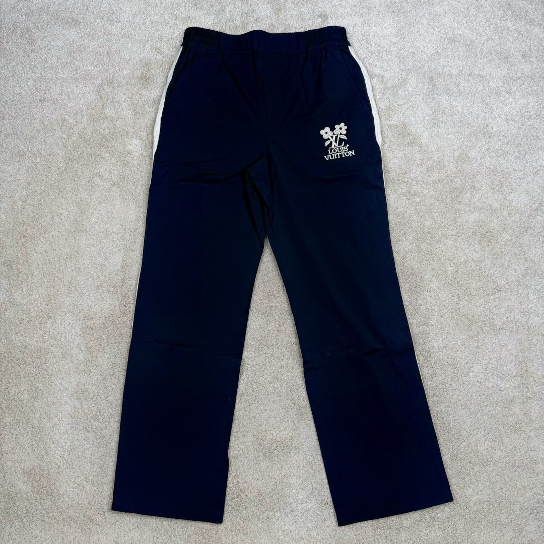 ＃GD广顶 LOUIS VUITTON SS24 x Tyler Logo Lv联名字母花卉刺绣针织运动裤毛织拼色绣花长裤 官网价：9250￥面料采用【75D锦纶斜纹布】底面做【涂胶工艺】增加面料手感挺度 前幅采用【日本进口田岛绣花机】刺绣【丝光棉线打底厚板胶】【立体锁边刺绣字母花朵】侧边织带裁片均【手工点位笔做标记】【平车来回车线贴织带】确保毛织织带平顺贴合于裁片 织带采用【德国进口斯托尔织机】织造【抽针立体提花纹路】织品针数密度高 织造过程中极其出现破洞 破洞织带只能报废 损耗率达到10%以上 腰内里配套【双层棉织带腰绳】抽绳头【手工缝制五金吊钟】尺码：44 46 48 50-选品中心