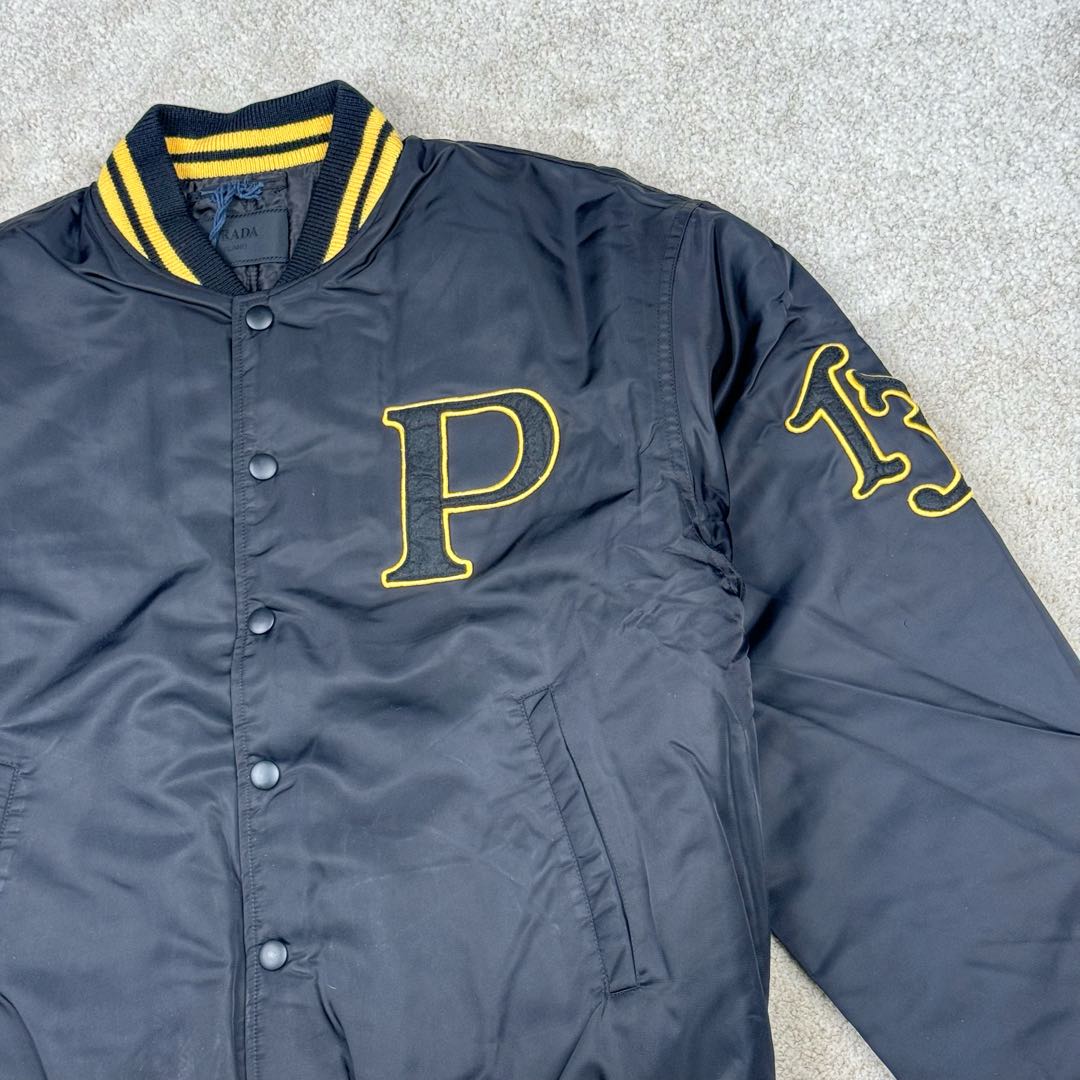 图片[9]-＃GD广顶 PRADA FW24 普拉达字母印花条纹单排扣飞行员夹克外套 黑色 官网价：19300￥（1908C）采用【100%锦纶斜纹面料】【厚度75D】底面做过胶增加面料手感挺度 采用【200D无妨底布】【激光烧花切割章仔】外围采用【国产高速机】【涤纶材质丝光线包边刺绣】开章仔模版【手摇绣花机贴裁片章仔】采用【人造丝斜纹缎面里布】【2寸双针间1200#洗水棉横条】螺纹采用【ADF加长机】织造【10s精梳棉色纱+2根氨纶高丝】-选品中心