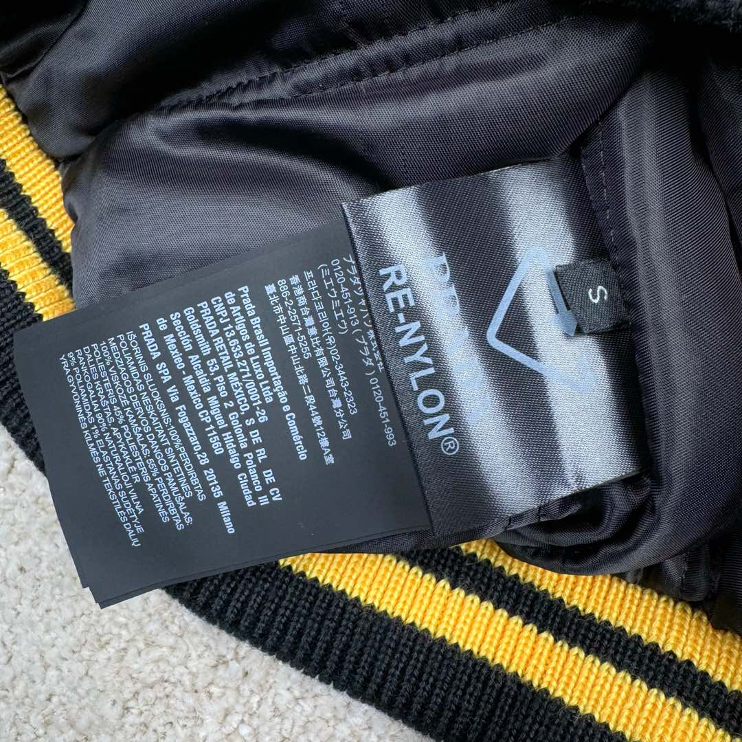 图片[12]-＃GD广顶 PRADA FW24 普拉达字母印花条纹单排扣飞行员夹克外套 黑色 官网价：19300￥（1908C）采用【100%锦纶斜纹面料】【厚度75D】底面做过胶增加面料手感挺度 采用【200D无妨底布】【激光烧花切割章仔】外围采用【国产高速机】【涤纶材质丝光线包边刺绣】开章仔模版【手摇绣花机贴裁片章仔】采用【人造丝斜纹缎面里布】【2寸双针间1200#洗水棉横条】螺纹采用【ADF加长机】织造【10s精梳棉色纱+2根氨纶高丝】-选品中心