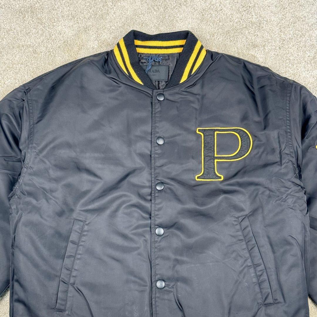 图片[7]-＃GD广顶 PRADA FW24 普拉达字母印花条纹单排扣飞行员夹克外套 黑色 官网价：19300￥（1908C）采用【100%锦纶斜纹面料】【厚度75D】底面做过胶增加面料手感挺度 采用【200D无妨底布】【激光烧花切割章仔】外围采用【国产高速机】【涤纶材质丝光线包边刺绣】开章仔模版【手摇绣花机贴裁片章仔】采用【人造丝斜纹缎面里布】【2寸双针间1200#洗水棉横条】螺纹采用【ADF加长机】织造【10s精梳棉色纱+2根氨纶高丝】-选品中心