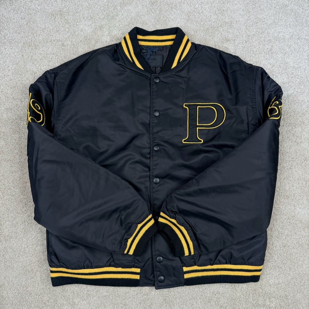 图片[2]-＃GD广顶 PRADA FW24 普拉达字母印花条纹单排扣飞行员夹克外套 黑色 官网价：19300￥（1908C）采用【100%锦纶斜纹面料】【厚度75D】底面做过胶增加面料手感挺度 采用【200D无妨底布】【激光烧花切割章仔】外围采用【国产高速机】【涤纶材质丝光线包边刺绣】开章仔模版【手摇绣花机贴裁片章仔】采用【人造丝斜纹缎面里布】【2寸双针间1200#洗水棉横条】螺纹采用【ADF加长机】织造【10s精梳棉色纱+2根氨纶高丝】-选品中心