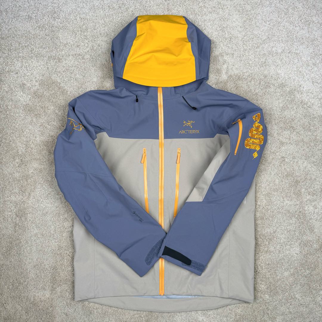 图片[2]-＃TZD Arcteryx Alpha SV 7 GORE-TEX Pro 始祖鸟第七代刺绣Logo图案休闲运动连帽拉链硬壳户外远足防水冲锋衣 蛇年限定 台州顶级批次 现货供应众所周日每年始祖鸟都会以十二生肖为思路出一款联名款的新年限定，今年也不例外此次的蛇年限定胸口logo为金标衣袖上的蛇形图案也很吸睛帽子上还有蛇鳞为点缀整个衣服的颜色为金黄-深蓝-棕整体看上去很亮设计感拉满 颜色搭配也很好! – Alpha SV JACKET 硬壳限定款Alpha SV JACKET 在袖口和内侧口袋饰有蛇形图案， – 限定款的帽子边缘同样点缀着蛇鳞印花设计 蛇“名”所代表的坚韧精神，正如始祖鸟高山精神所倡导的无畏挑战、勇往直前。 NO1. 防水：防水为国际ISO标准90(ISO4)级别达到荷叶水珠滚动效果! NO2. 面料：采用2L双层Gore-tex面料，面料表层做超高强度防水，内层覆膜，所以到达三层防水的效果，使成衣具有防水防污透气的出色效果。 NO3. 工艺：压胶采用的胶水为铁金刚胶条，市面销售的潜水服就是这个牌子的胶水，区别市面普通压胶(洗几次就开胶)咱家只管放心 NO4. 刺绣：进口百灵达刺绣机还原ZP。百灵达刺绣工整立体，饱满度立体感以及每个字母的神韵特点，一笔一划工工整整立体效果强烈 NO5. 辅料：原版正品五金配件，字体清晰立体与正品一致 尺码：S M L XL XXL-选品中心