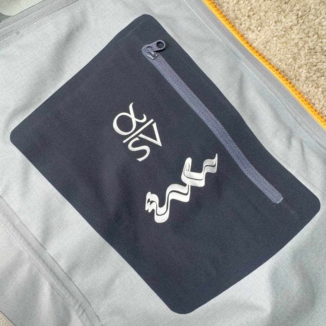 图片[13]-＃TZD Arcteryx Alpha SV 7 GORE-TEX Pro 始祖鸟第七代刺绣Logo图案休闲运动连帽拉链硬壳户外远足防水冲锋衣 蛇年限定 台州顶级批次 现货供应众所周日每年始祖鸟都会以十二生肖为思路出一款联名款的新年限定，今年也不例外此次的蛇年限定胸口logo为金标衣袖上的蛇形图案也很吸睛帽子上还有蛇鳞为点缀整个衣服的颜色为金黄-深蓝-棕整体看上去很亮设计感拉满 颜色搭配也很好! – Alpha SV JACKET 硬壳限定款Alpha SV JACKET 在袖口和内侧口袋饰有蛇形图案， – 限定款的帽子边缘同样点缀着蛇鳞印花设计 蛇“名”所代表的坚韧精神，正如始祖鸟高山精神所倡导的无畏挑战、勇往直前。 NO1. 防水：防水为国际ISO标准90(ISO4)级别达到荷叶水珠滚动效果! NO2. 面料：采用2L双层Gore-tex面料，面料表层做超高强度防水，内层覆膜，所以到达三层防水的效果，使成衣具有防水防污透气的出色效果。 NO3. 工艺：压胶采用的胶水为铁金刚胶条，市面销售的潜水服就是这个牌子的胶水，区别市面普通压胶(洗几次就开胶)咱家只管放心 NO4. 刺绣：进口百灵达刺绣机还原ZP。百灵达刺绣工整立体，饱满度立体感以及每个字母的神韵特点，一笔一划工工整整立体效果强烈 NO5. 辅料：原版正品五金配件，字体清晰立体与正品一致 尺码：S M L XL XXL-选品中心